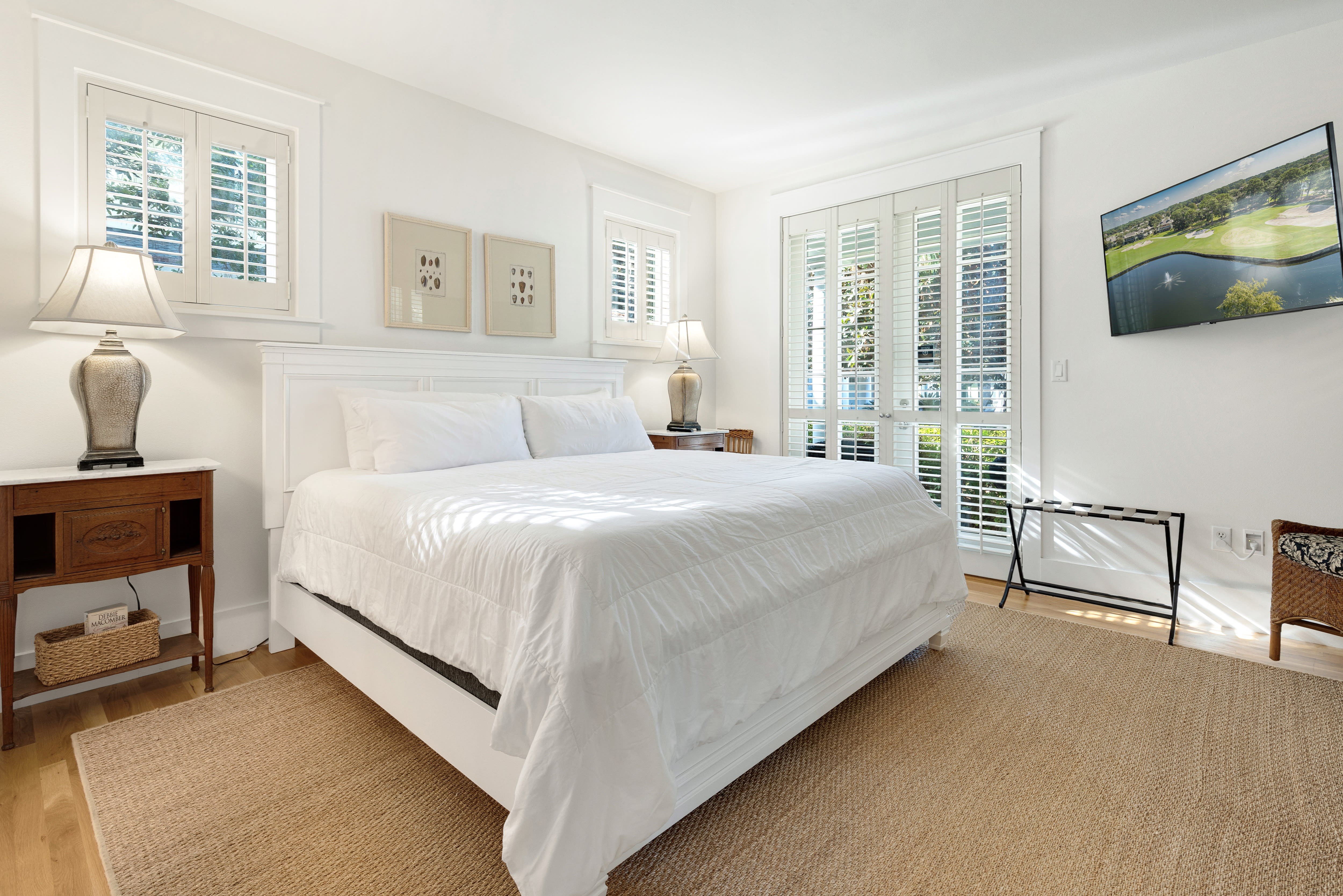 Wake up in your serene bedroom sanctuary, where crisp white linens meet natural light streaming through elegant shutters.