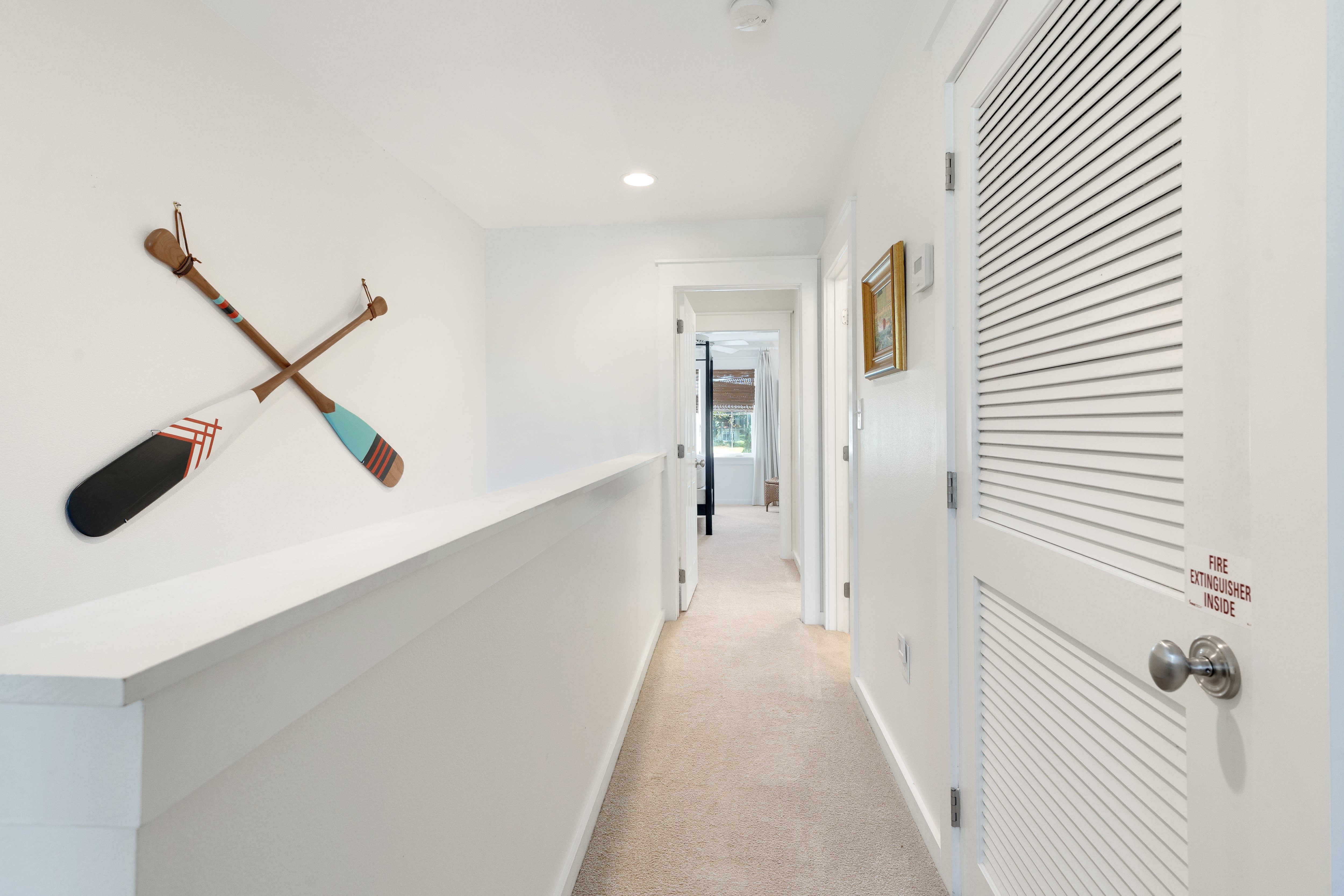 Navigate through this bright hallway where nautical charm meets modern comfort, leading you to your peaceful retreat.