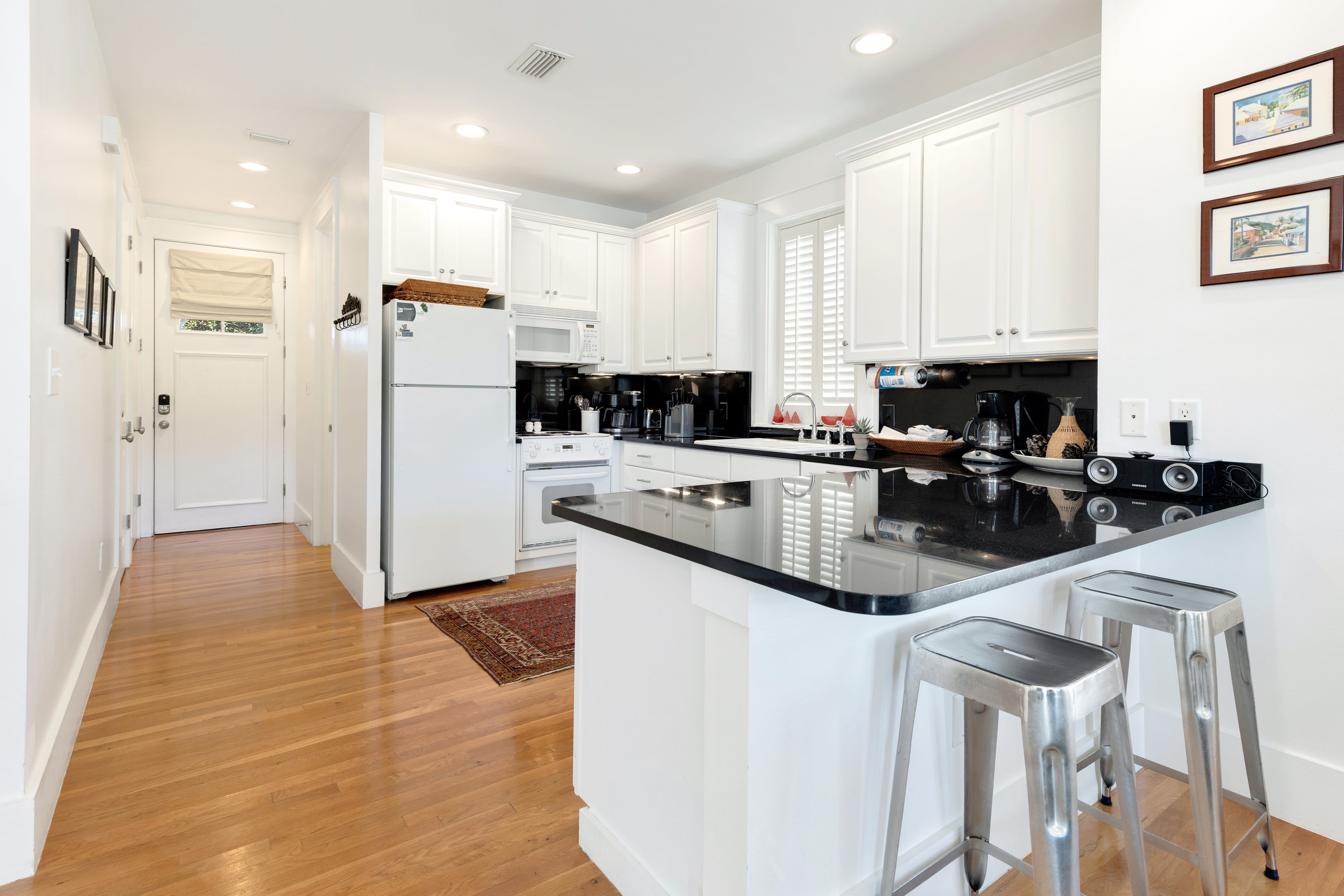 Your fully equipped kitchen features gleaming granite counters, white cabinetry, and modern stainless appliances—perfect for whipping up morning coffee or evening meals.