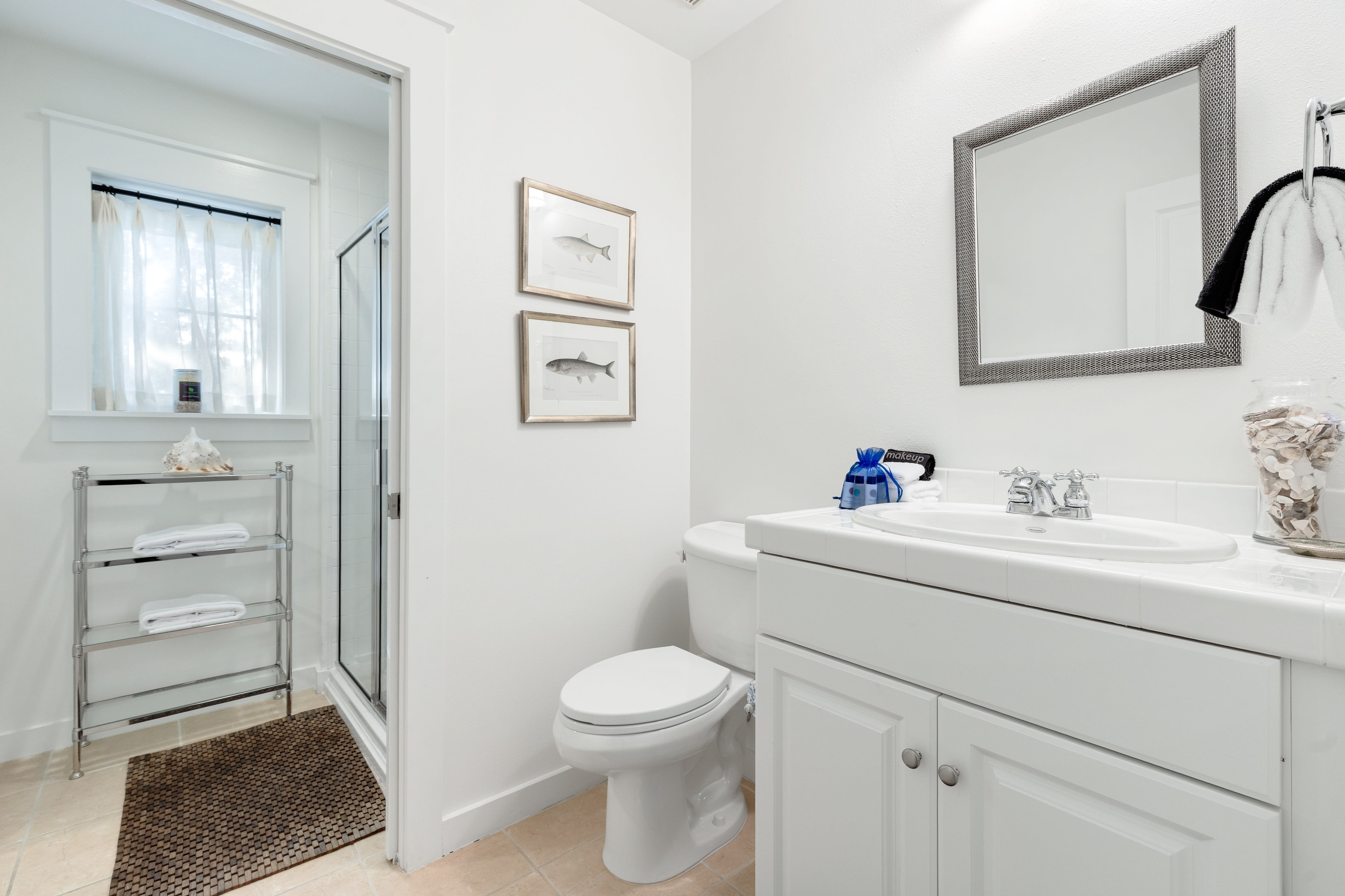 Refresh in your pristine bathroom with coastal charm, featuring a spacious vanity, glass shower, and thoughtful touches that make your morning routine feel luxurious.