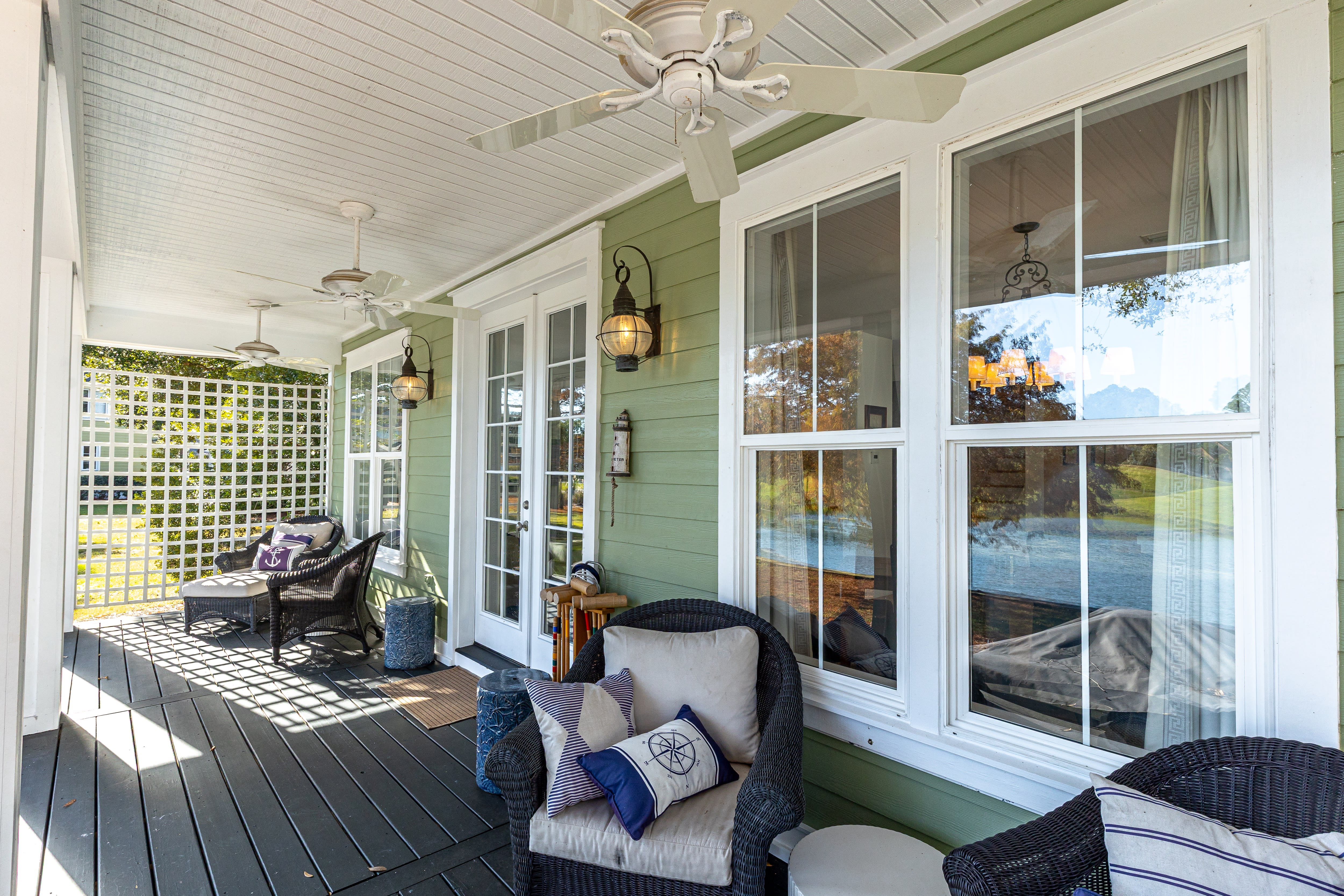 Unwind on your private covered porch with cozy wicker seating and gentle ceiling fans creating the perfect lakeside retreat.