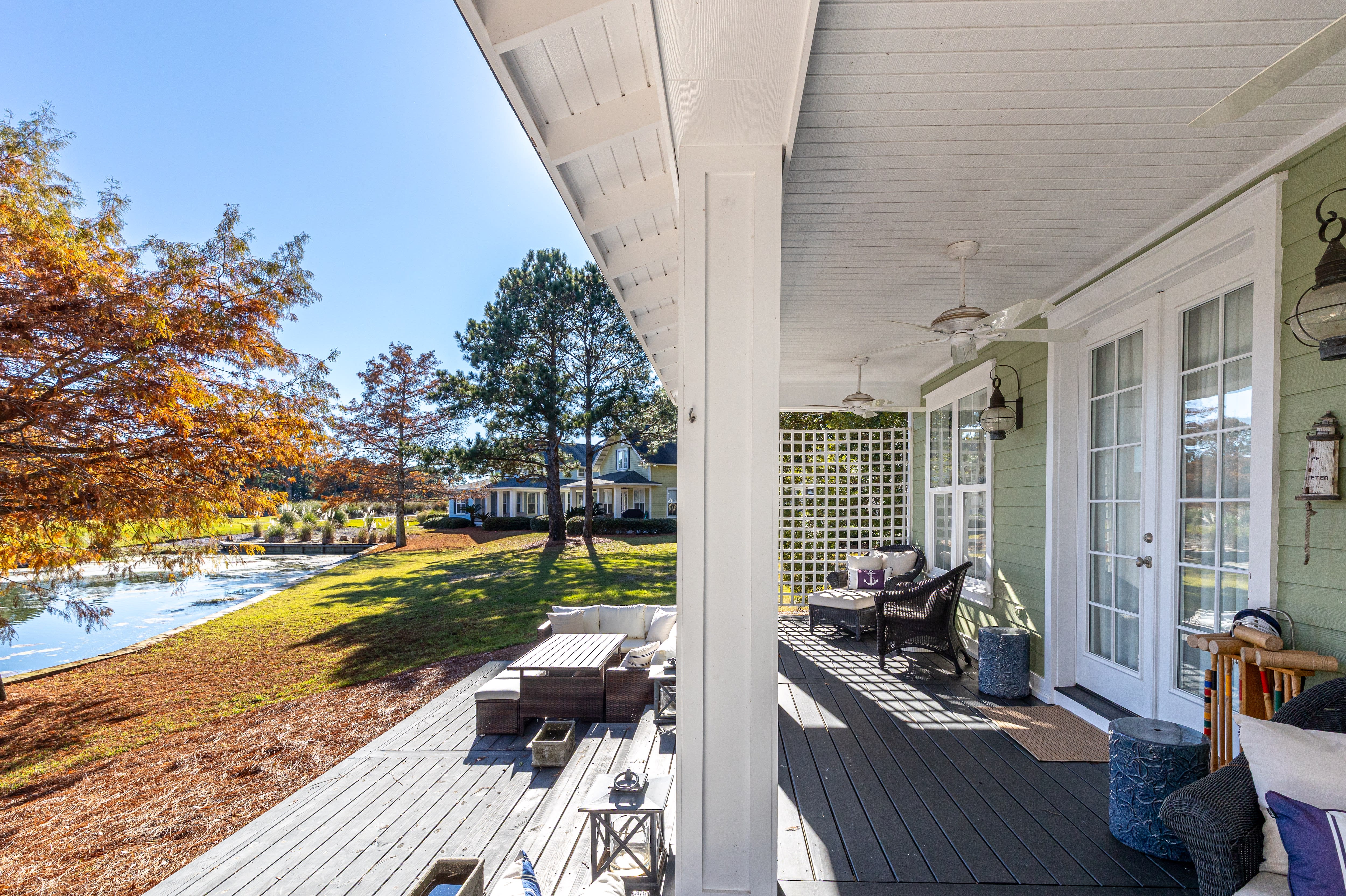 Charming lakeside cottage with covered porch overlooking autumn foliage and waterfront setting.