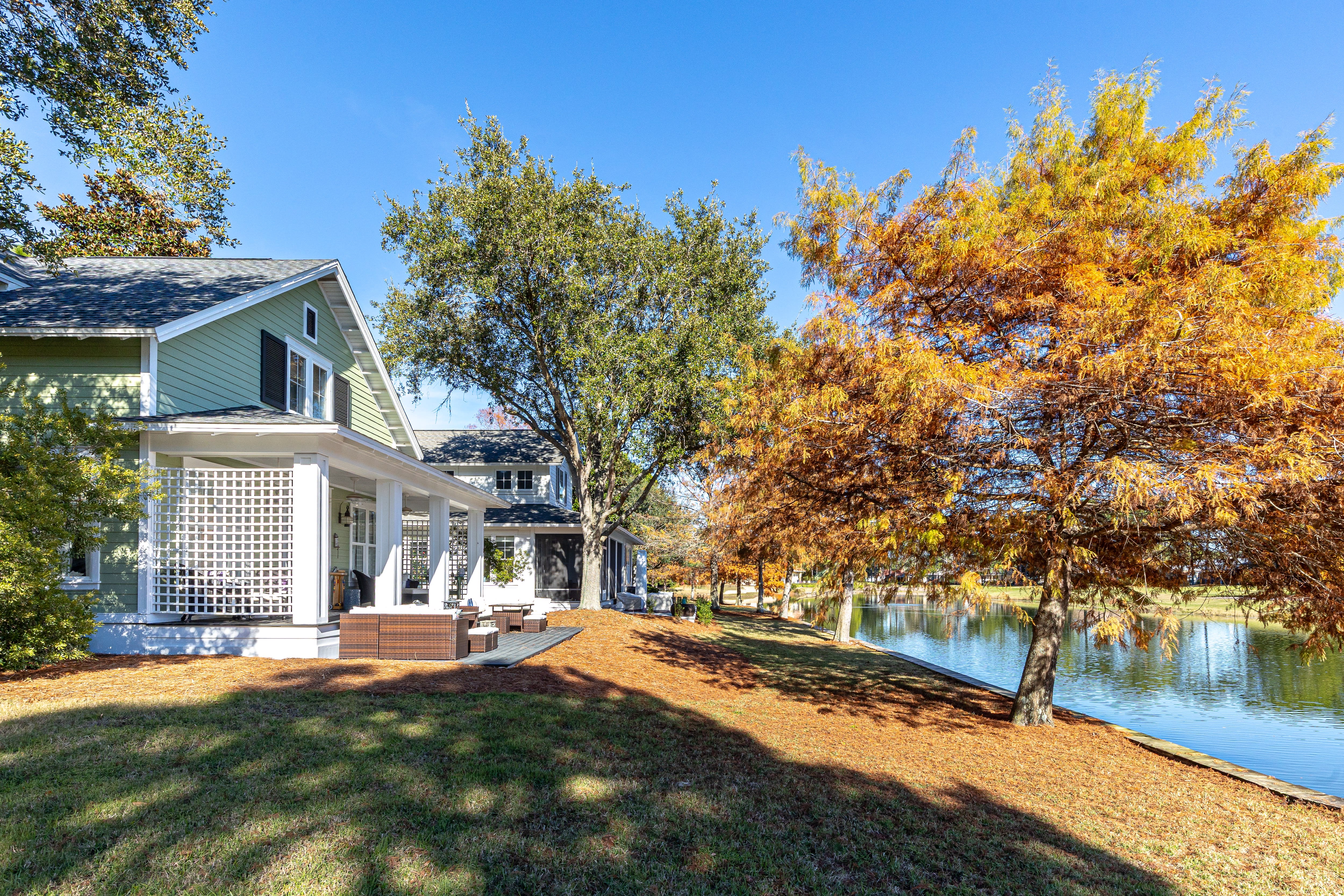 Charming lakefront cottage surrounded by vibrant autumn foliage and peaceful waterfront setting.
