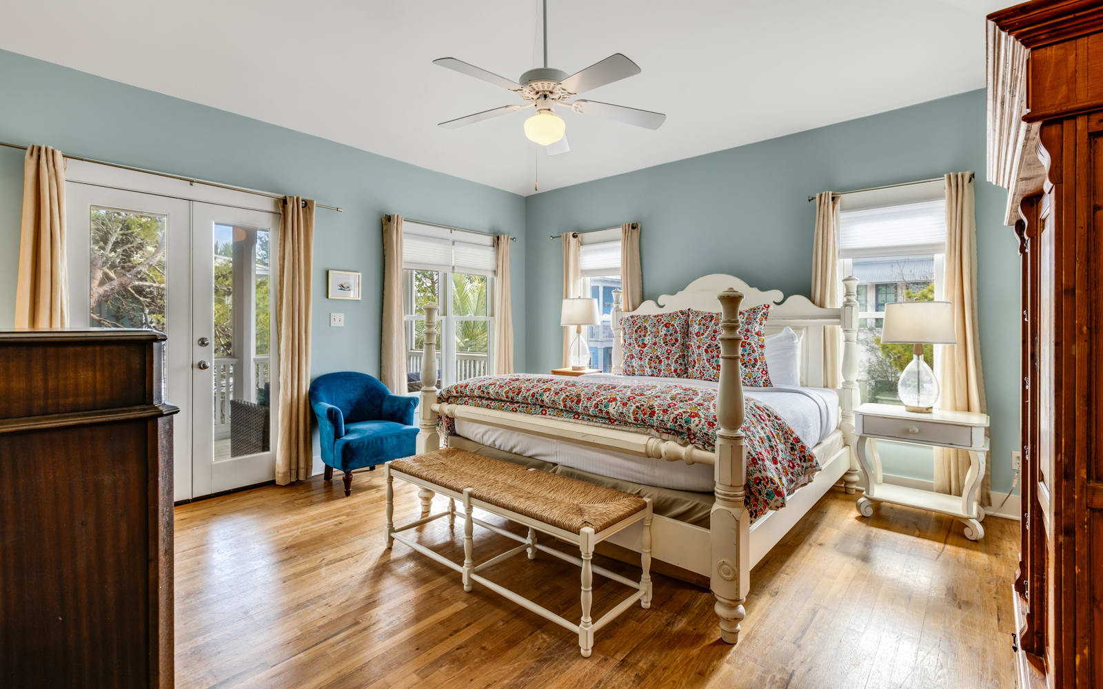 Unwind in this peaceful bedroom featuring soothing blue walls, gleaming hardwood floors, and French doors opening to your private balcony.