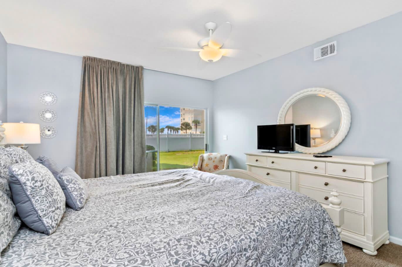 Drift off in your serene bedroom featuring soft blue walls, comfortable bedding, and peaceful garden views through your private window.