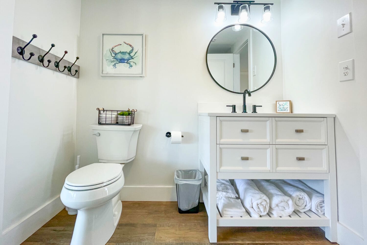 Step into your bright, coastal-themed bathroom with thoughtful touches like fresh towels and charming nautical decor waiting for you.