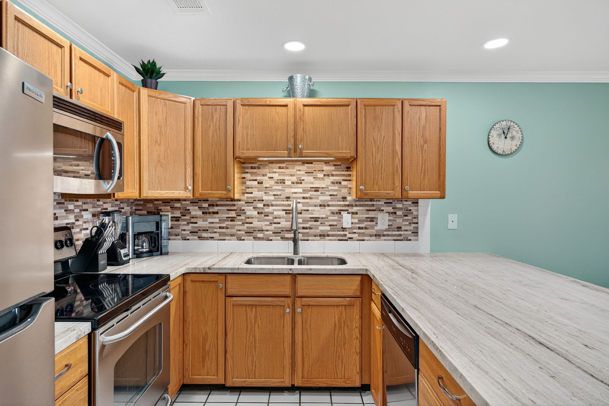 Your fully equipped kitchen features modern appliances, granite countertops, and warm wood cabinetry - perfect for preparing meals during your stay.