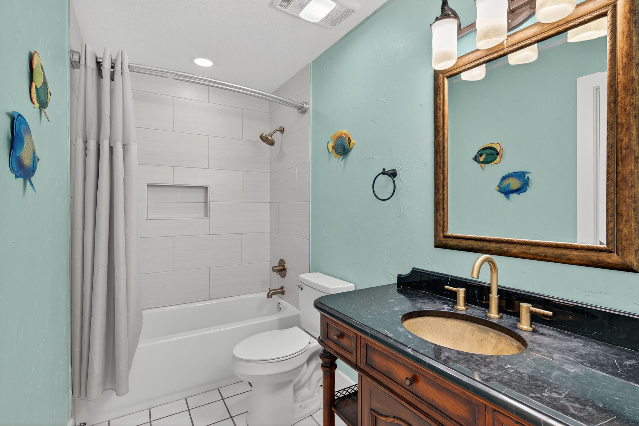 Refresh in your charming nautical bathroom with ocean-inspired décor, marble countertops, and a relaxing tub-shower combo for your coastal getaway.