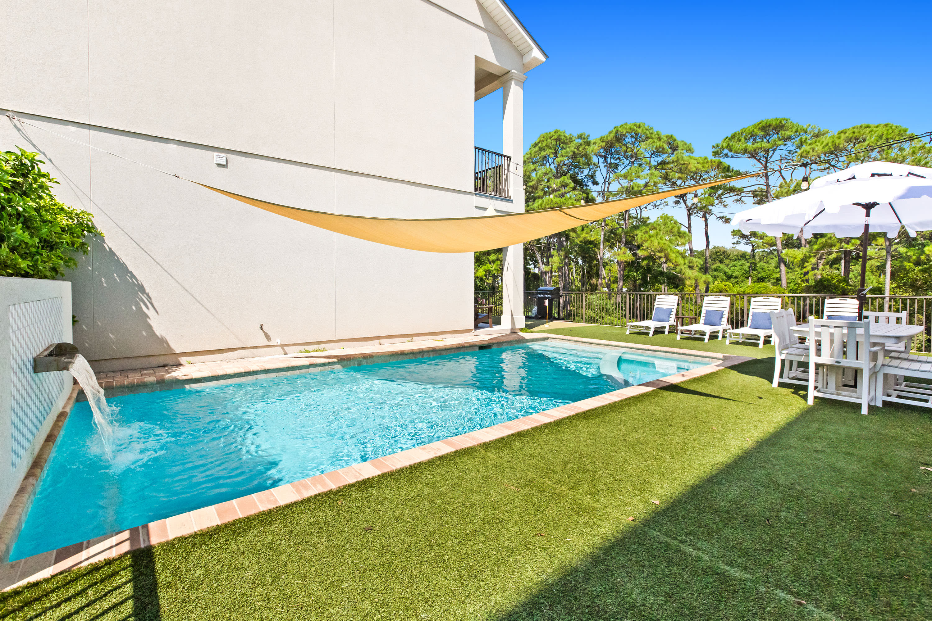 The fenced-in yard features turf for an evergreen experience