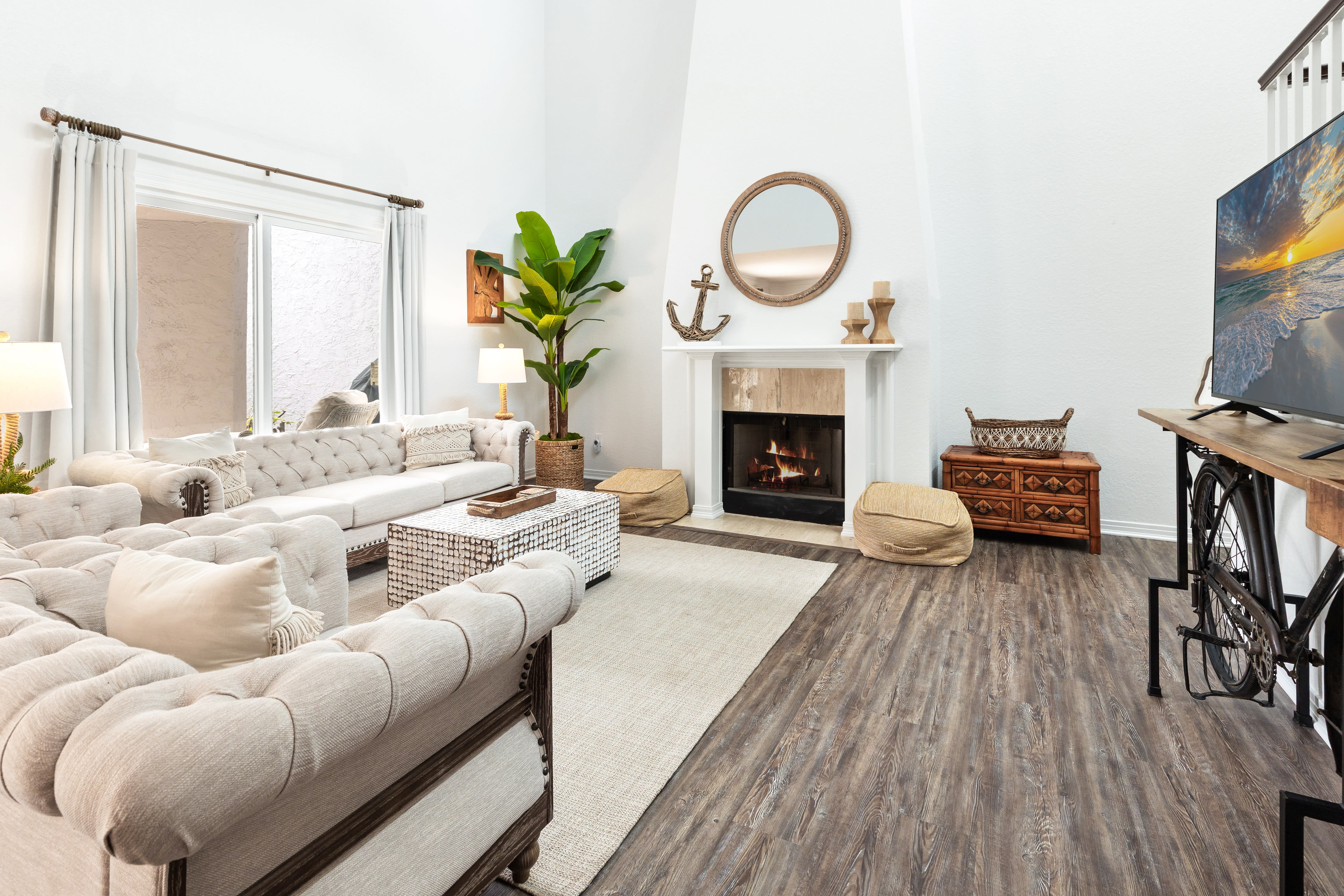 Sink into plush sectional seating by your cozy fireplace, where natural light streams through and coastal vibes create perfect relaxation.