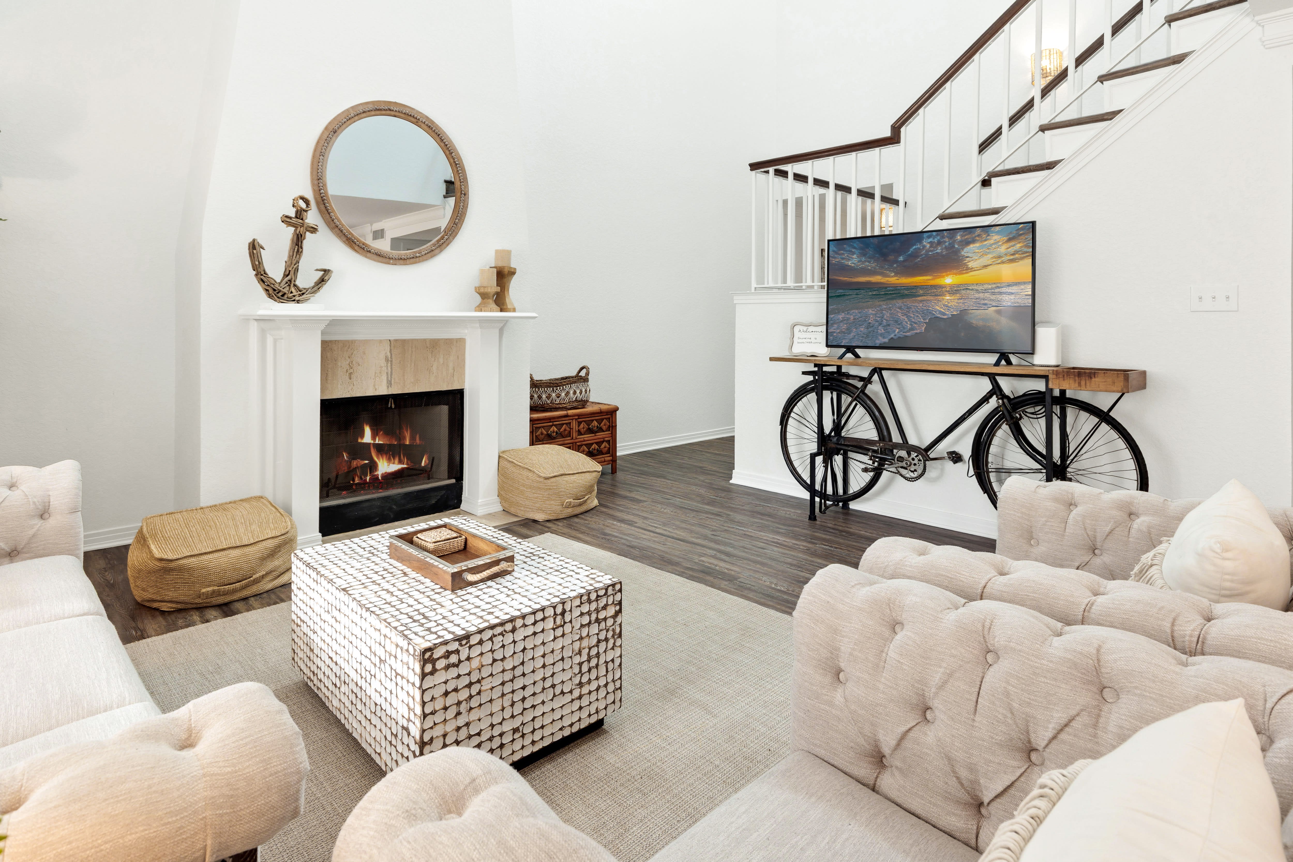 Cozy up by your crackling fireplace in this stylishly furnished living room, complete with plush seating and modern entertainment setup.