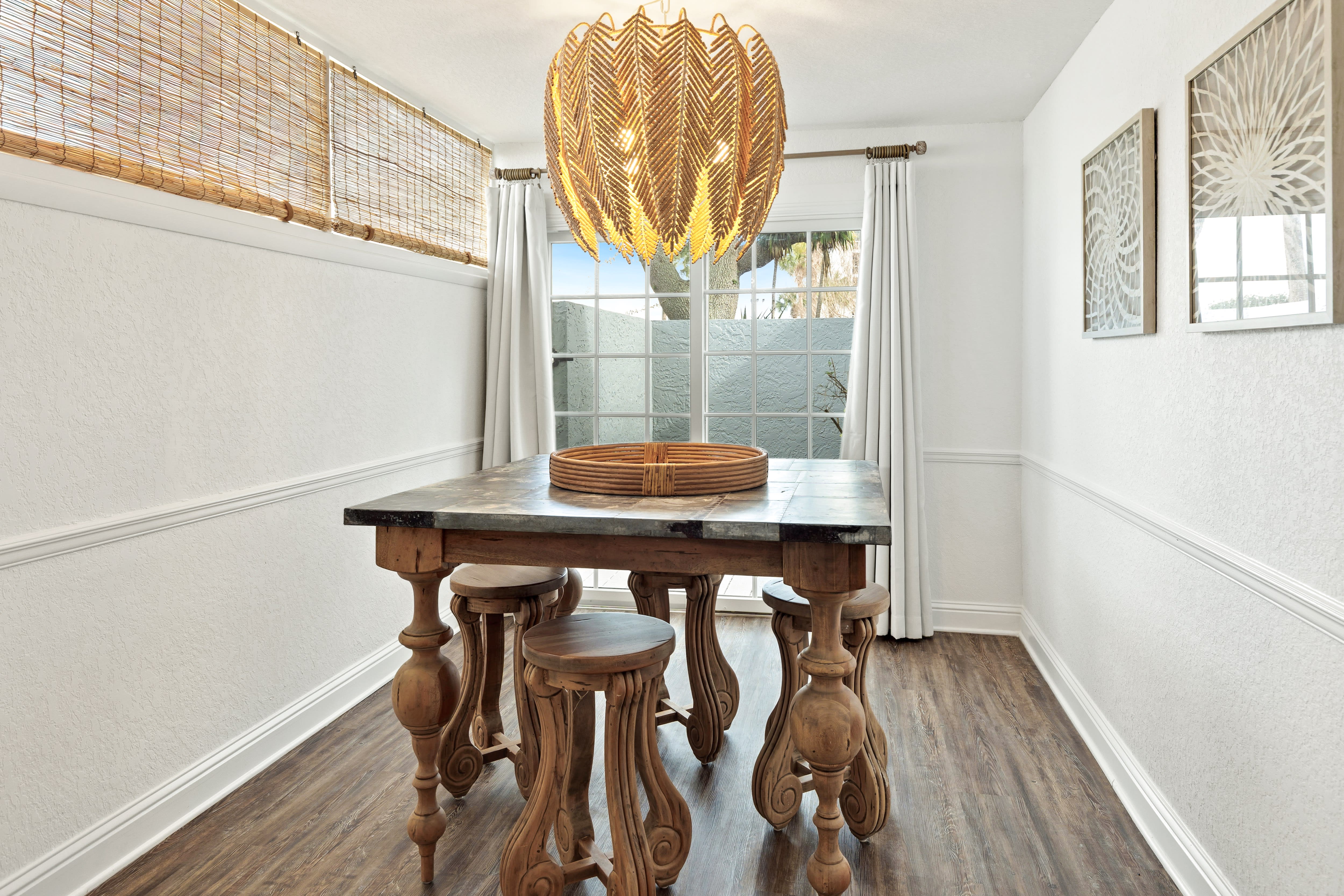 Gather around this elegant dining table with its striking feather chandelier, where your meals become memorable moments in this beautifully appointed space.