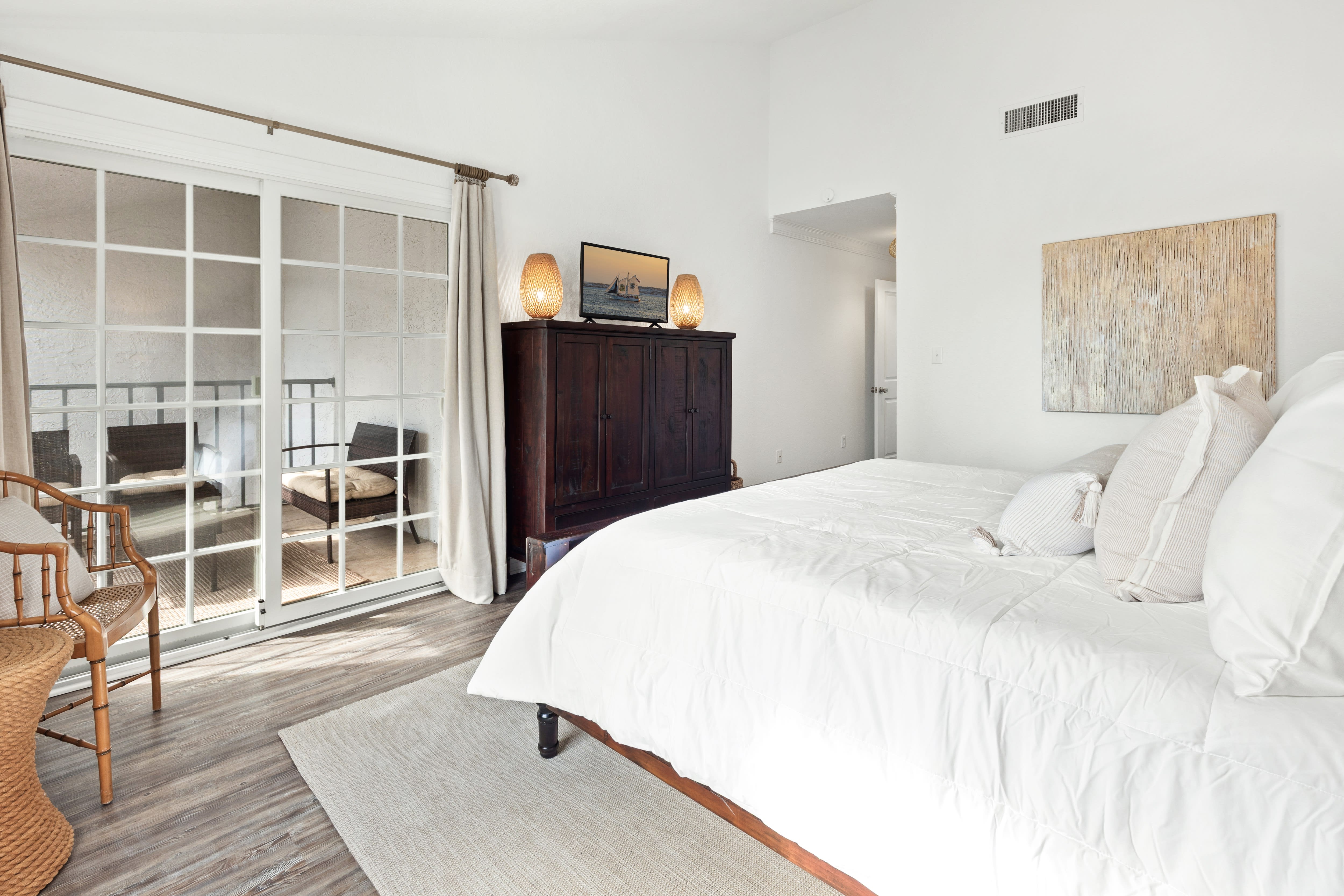 Sink into crisp white linens in your serene bedroom, where French doors open to your private balcony for morning coffee moments.