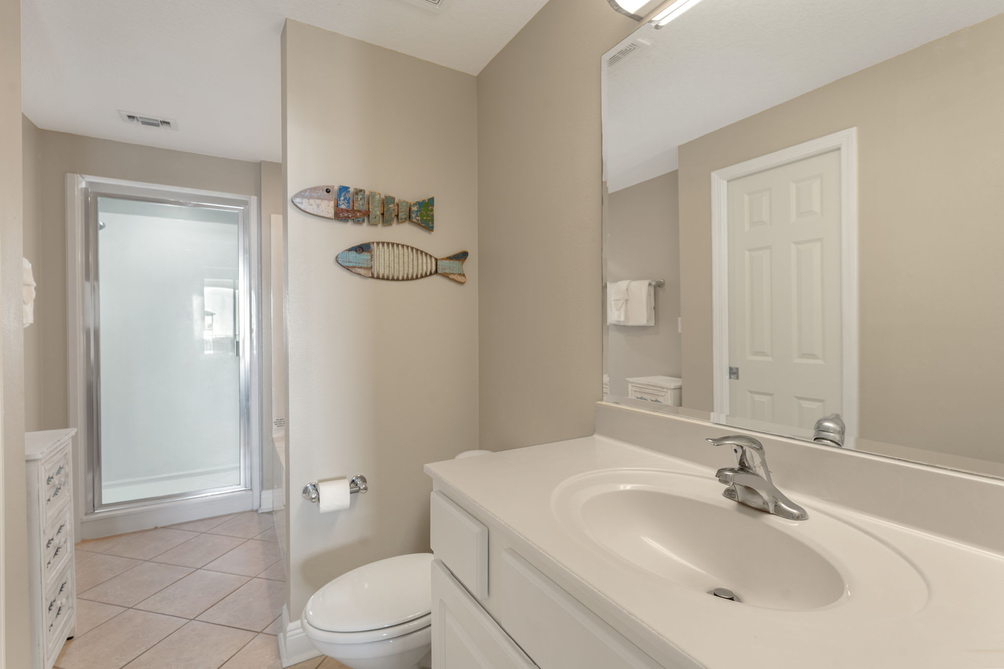 Step into the serene Primary bathroom with coastal touches and a refreshing shower to wash away the day's adventures.