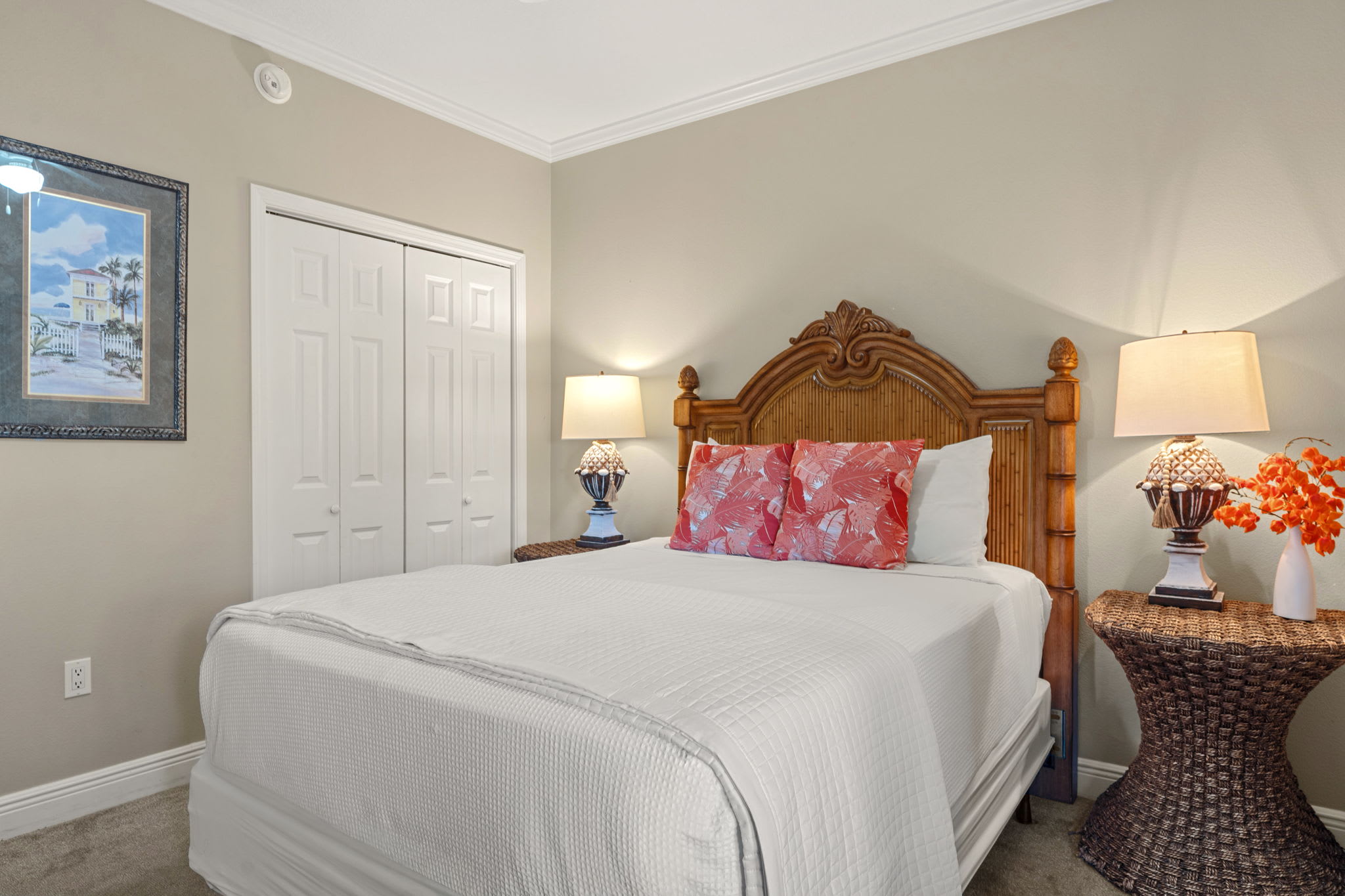 Sink into crisp white linens and tropical comfort in the peaceful bedroom retreat, complete with charming wicker touches and warm coastal lighting.