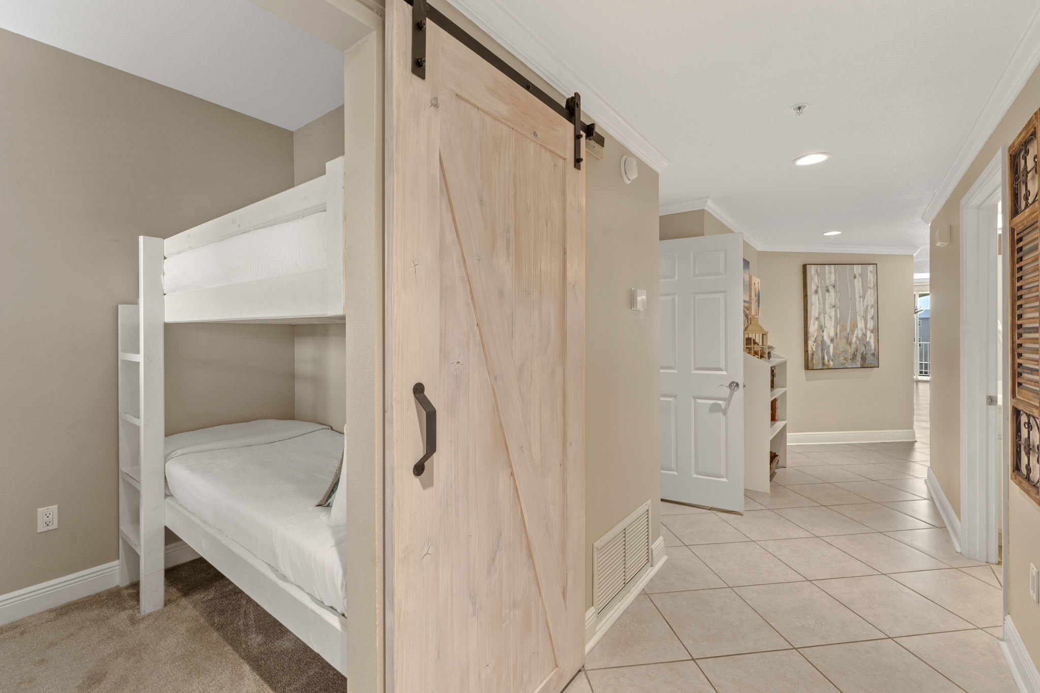 Kids will love this clever bunk bed setup with a rustic barn door for privacy and cozy carpeted floors.