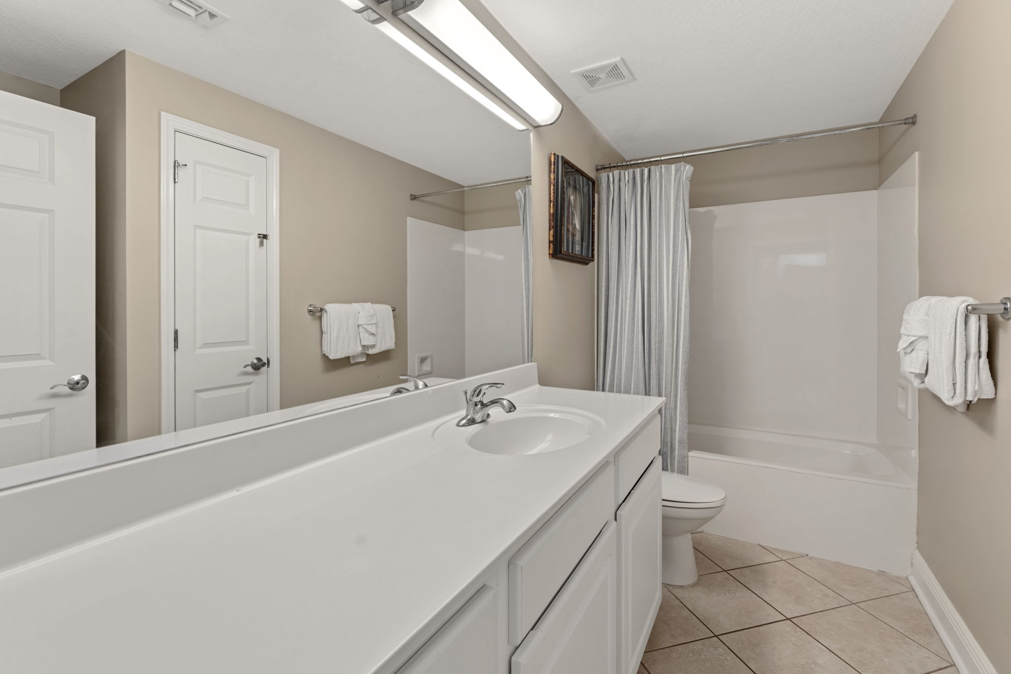 Spacious bathroom features a tub, fresh towels, and clean modern finishes for ultimate relaxation.