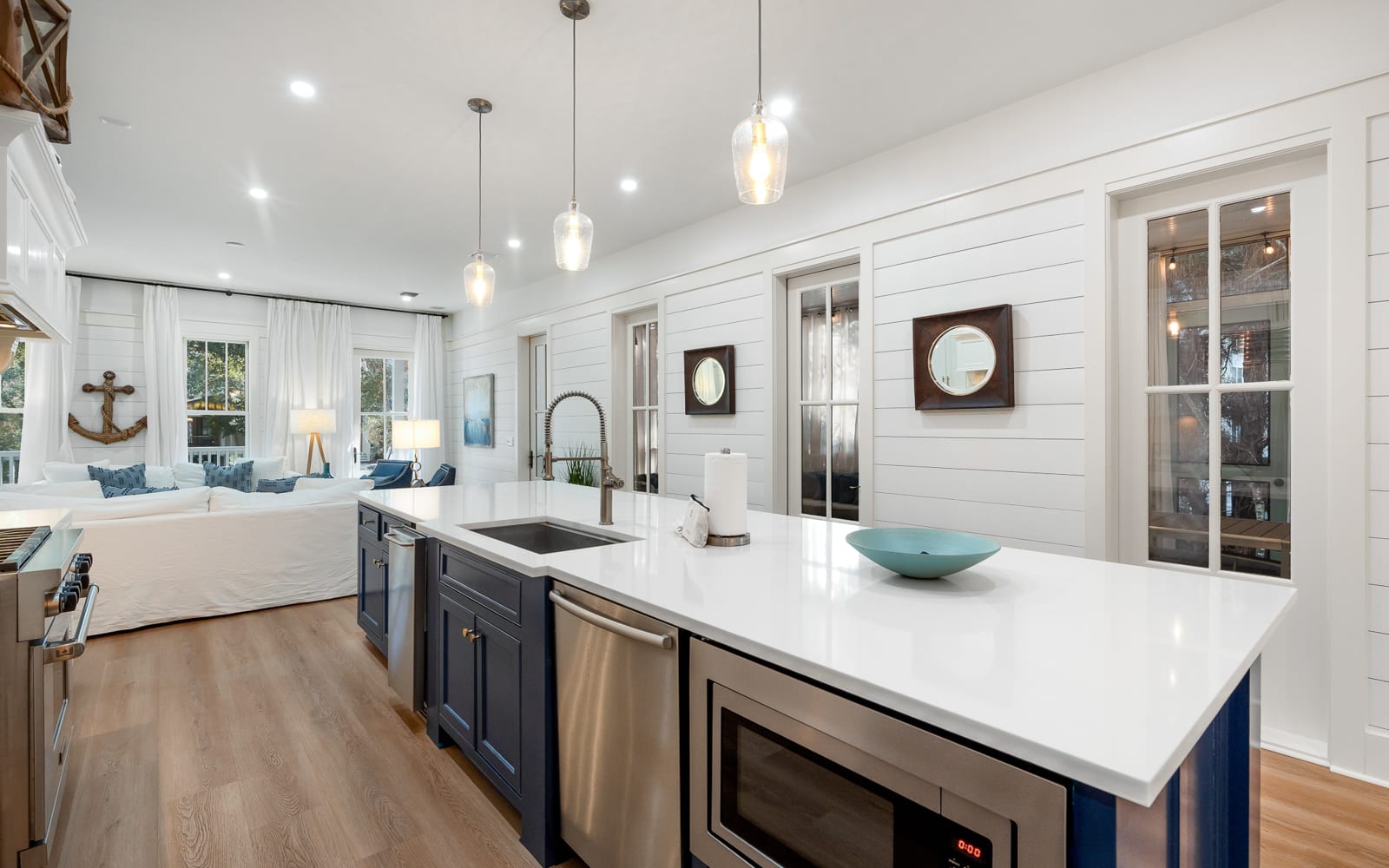 Your modern coastal kitchen invites culinary adventures with gleaming countertops, premium appliances, and charming nautical touches throughout.