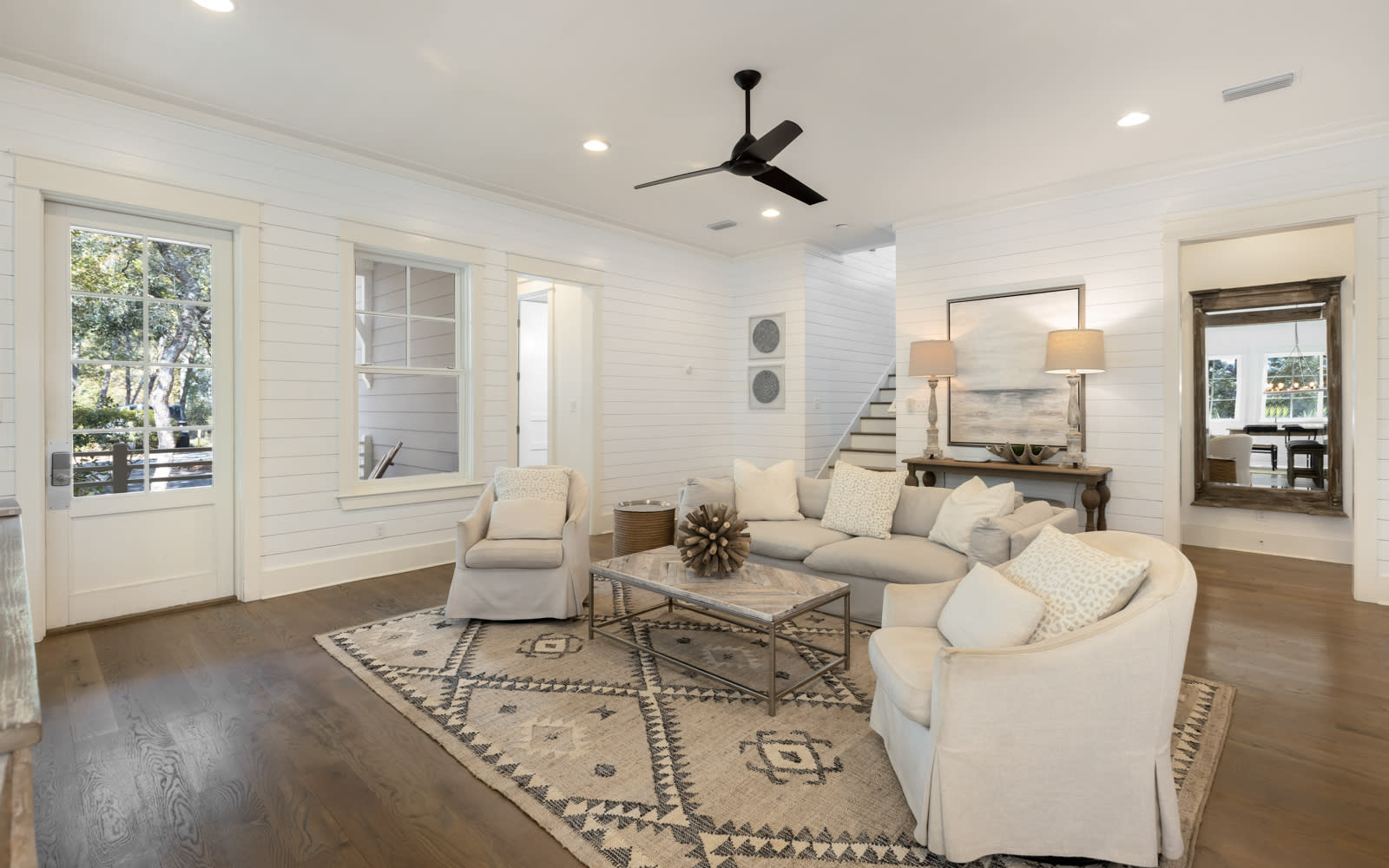 Relax in your spacious living room with plush sectional seating, stylish décor, and ceiling fan for perfect comfort.