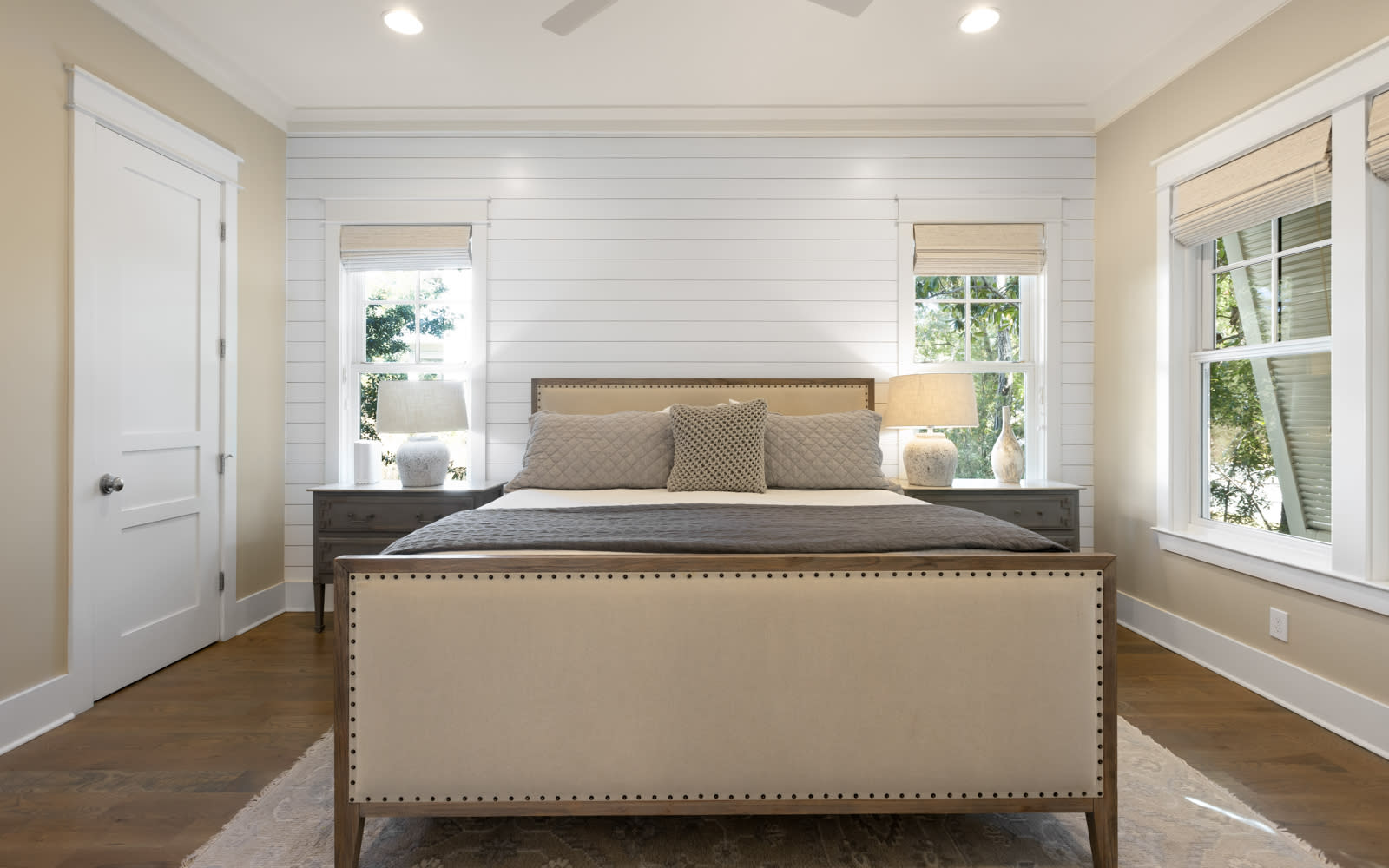 Sink into this elegant bedroom's plush bedding after your day exploring, with natural light streaming through stylish windows.