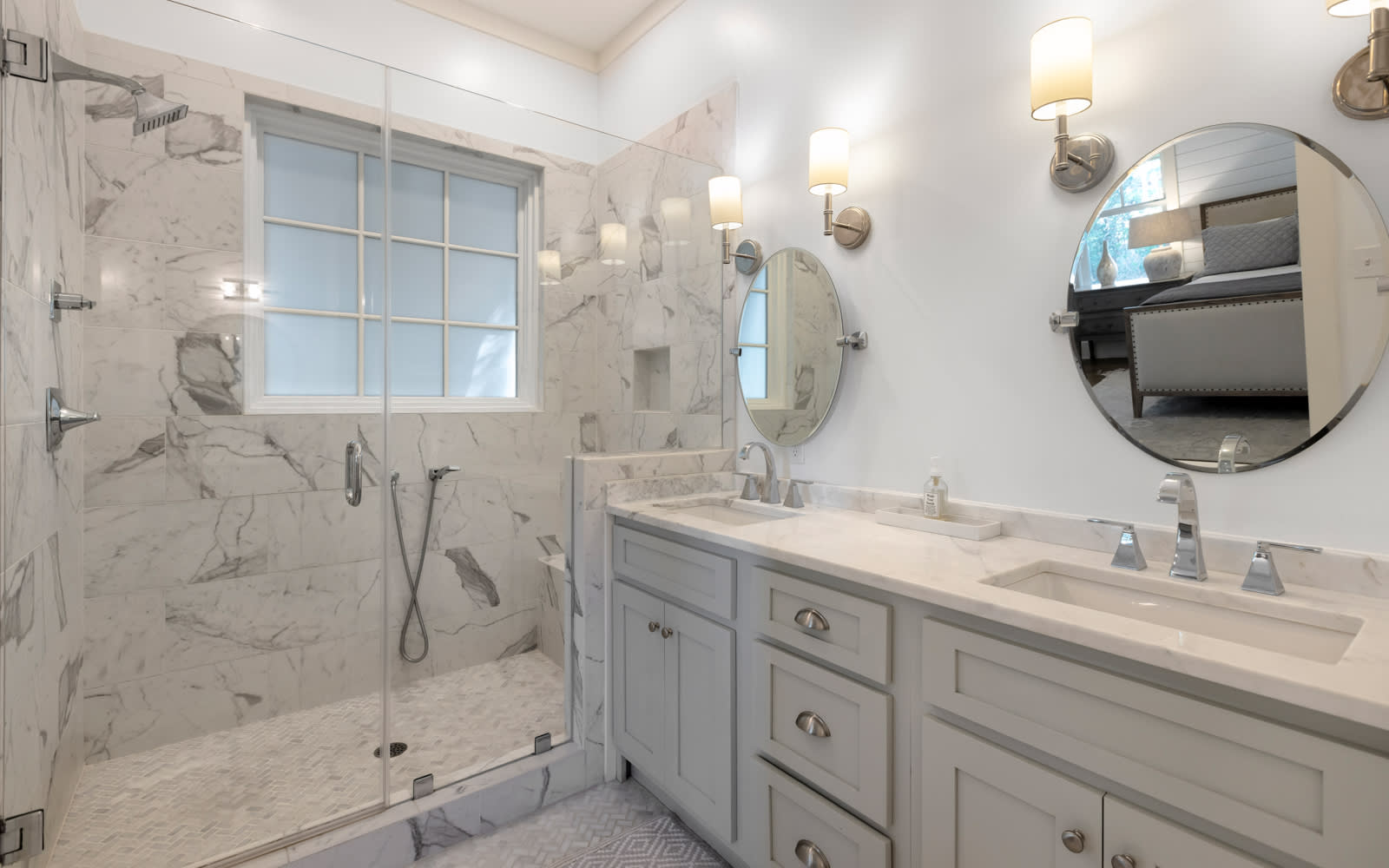 Step into your luxurious marble bathroom with a spacious walk-in shower and elegant dual vanities, perfect for your morning routine.