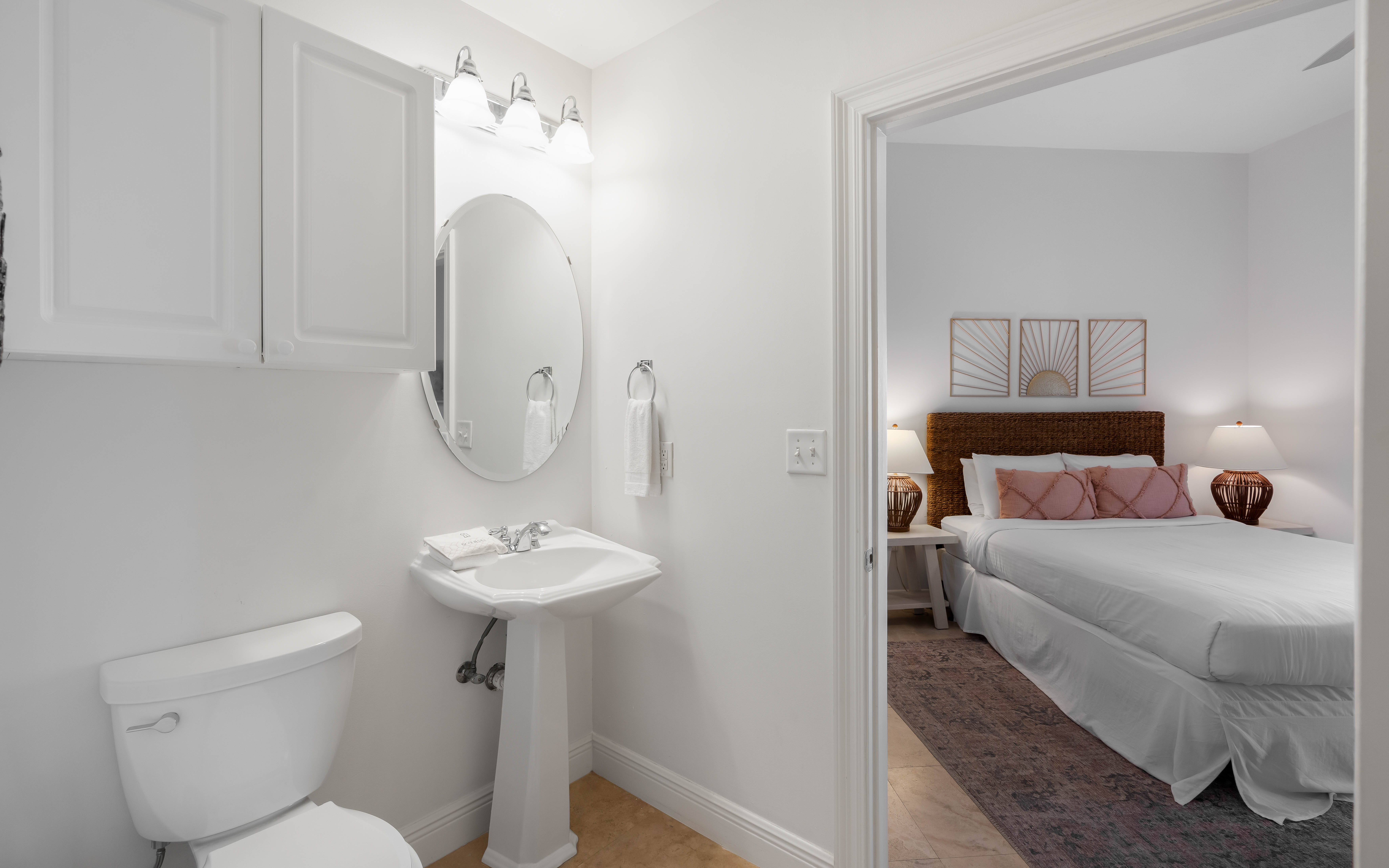 Your ensuite bathroom features a pristine pedestal sink and well-appointed fixtures, with your comfortable bedroom just steps away.