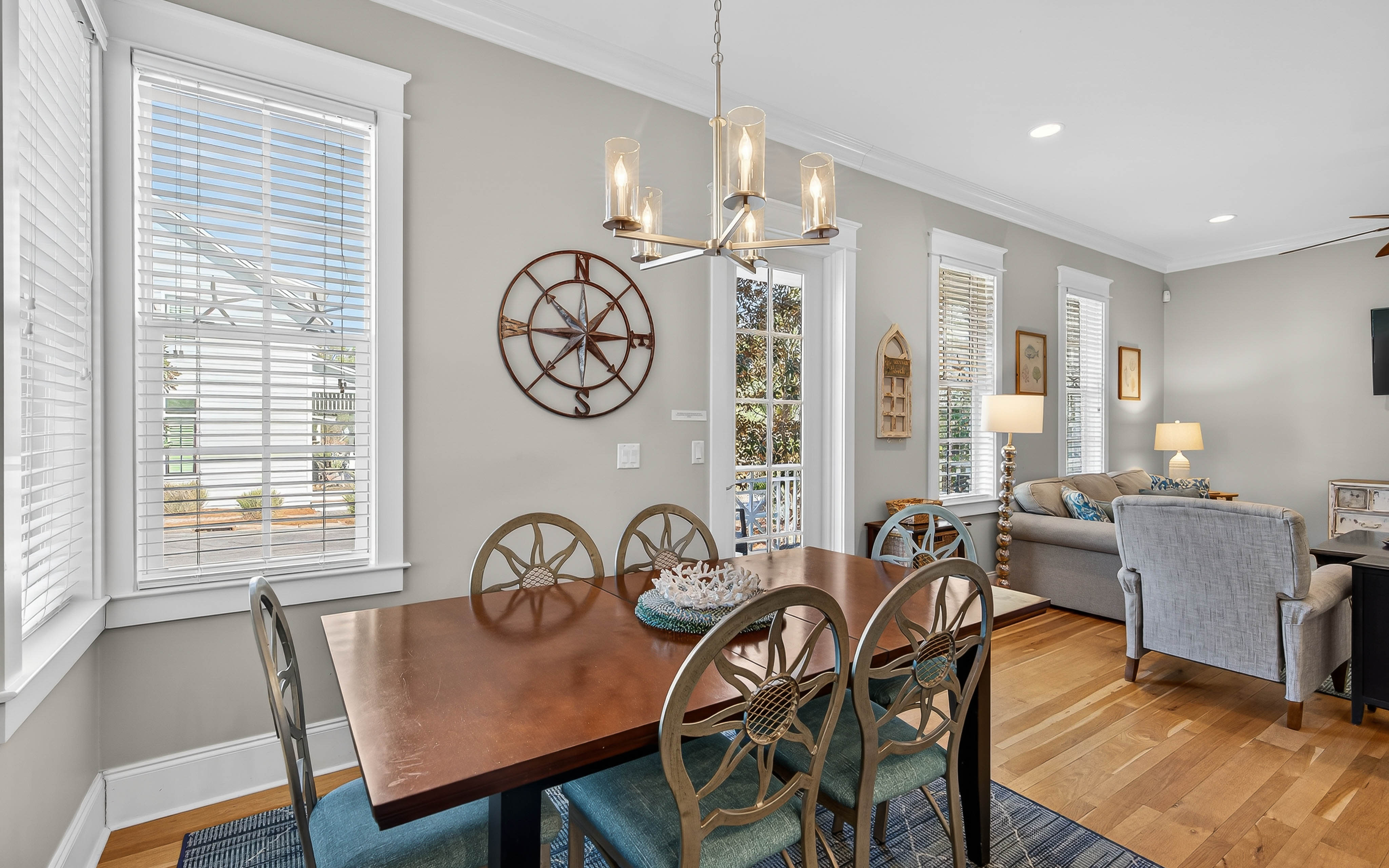 Gather around your elegant dining table where nautical touches and warm lighting create memorable meals together.