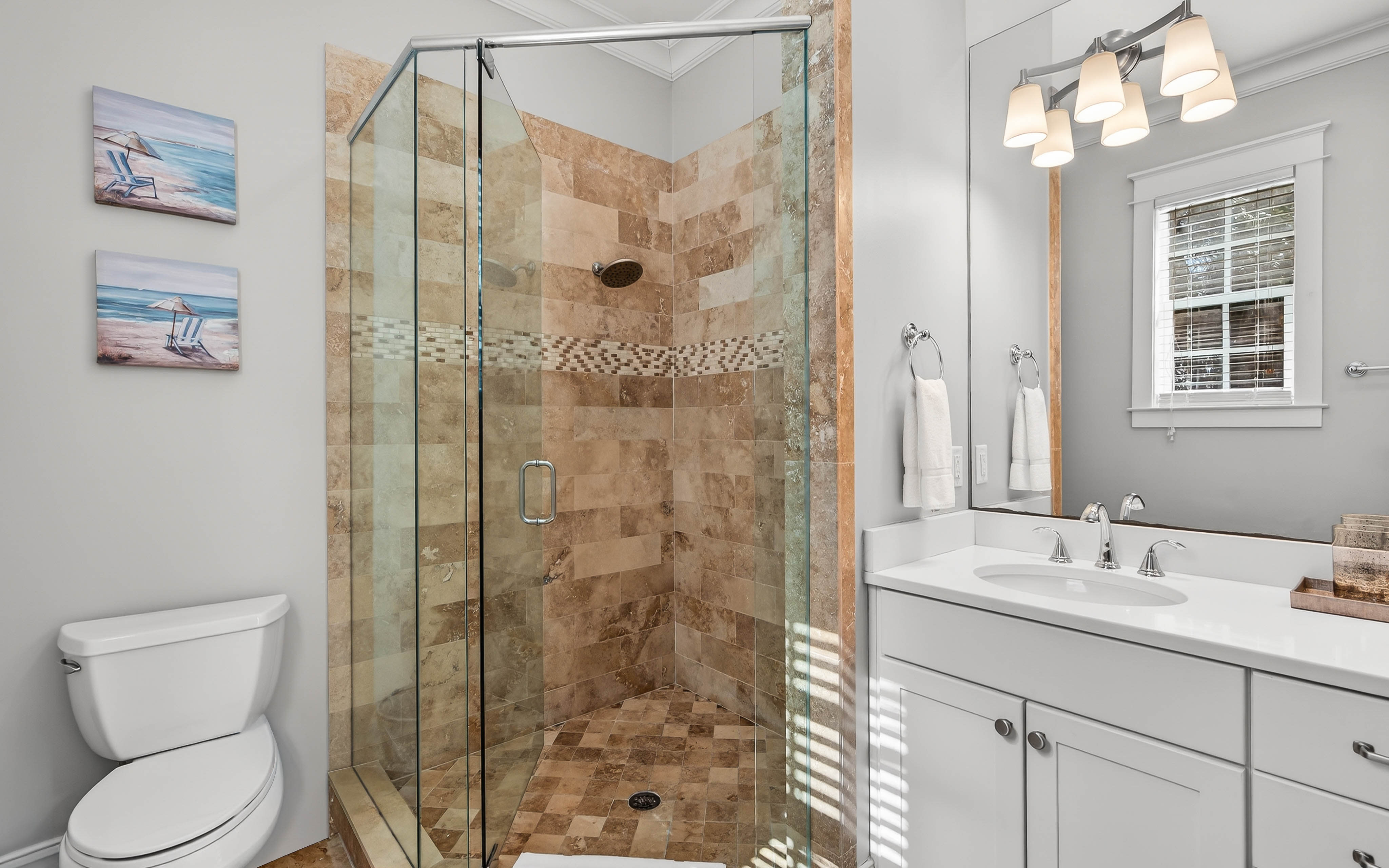 Indulge in your private spa-like bathroom with beautiful stone tile shower, double vanity, and elegant lighting for your morning routine.