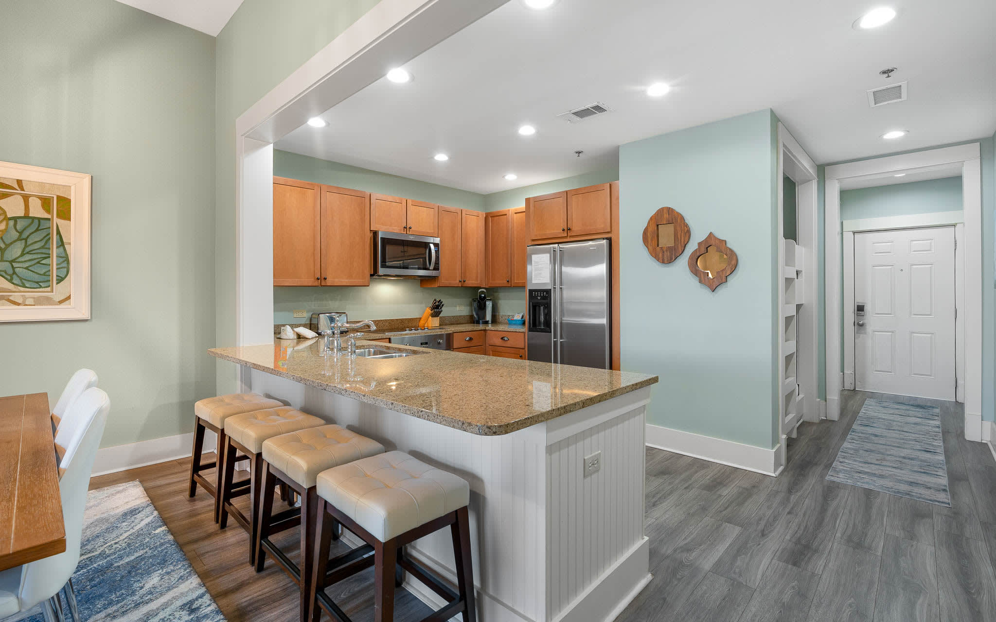 Your open-concept kitchen flows seamlessly into the living space, featuring granite countertops, stainless appliances, and a breakfast bar perfect for morning coffee.