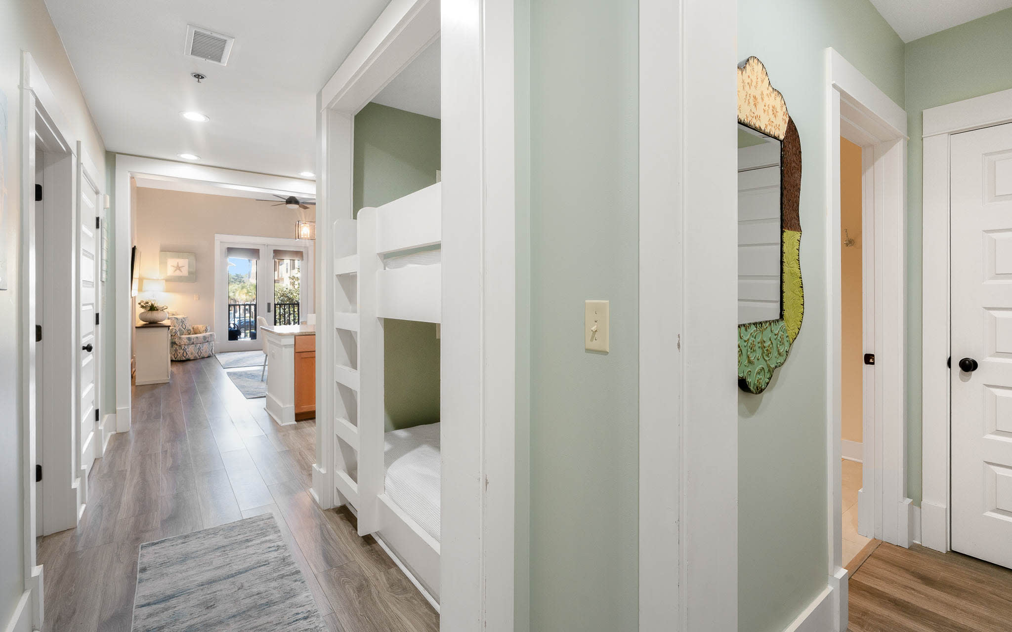 Step into your stylish hallway where thoughtful design meets comfort—built-in bunks create cozy sleeping nooks while warm wood floors guide you through this welcoming space.