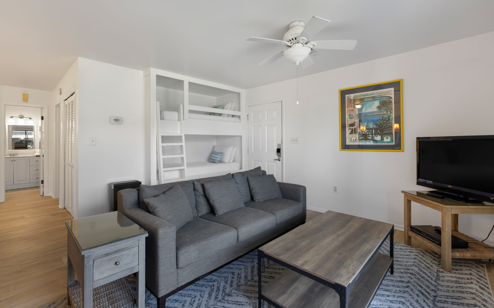 Your bright living room features a comfy sofa, entertainment center, and built-in bunk beds for extra guests.