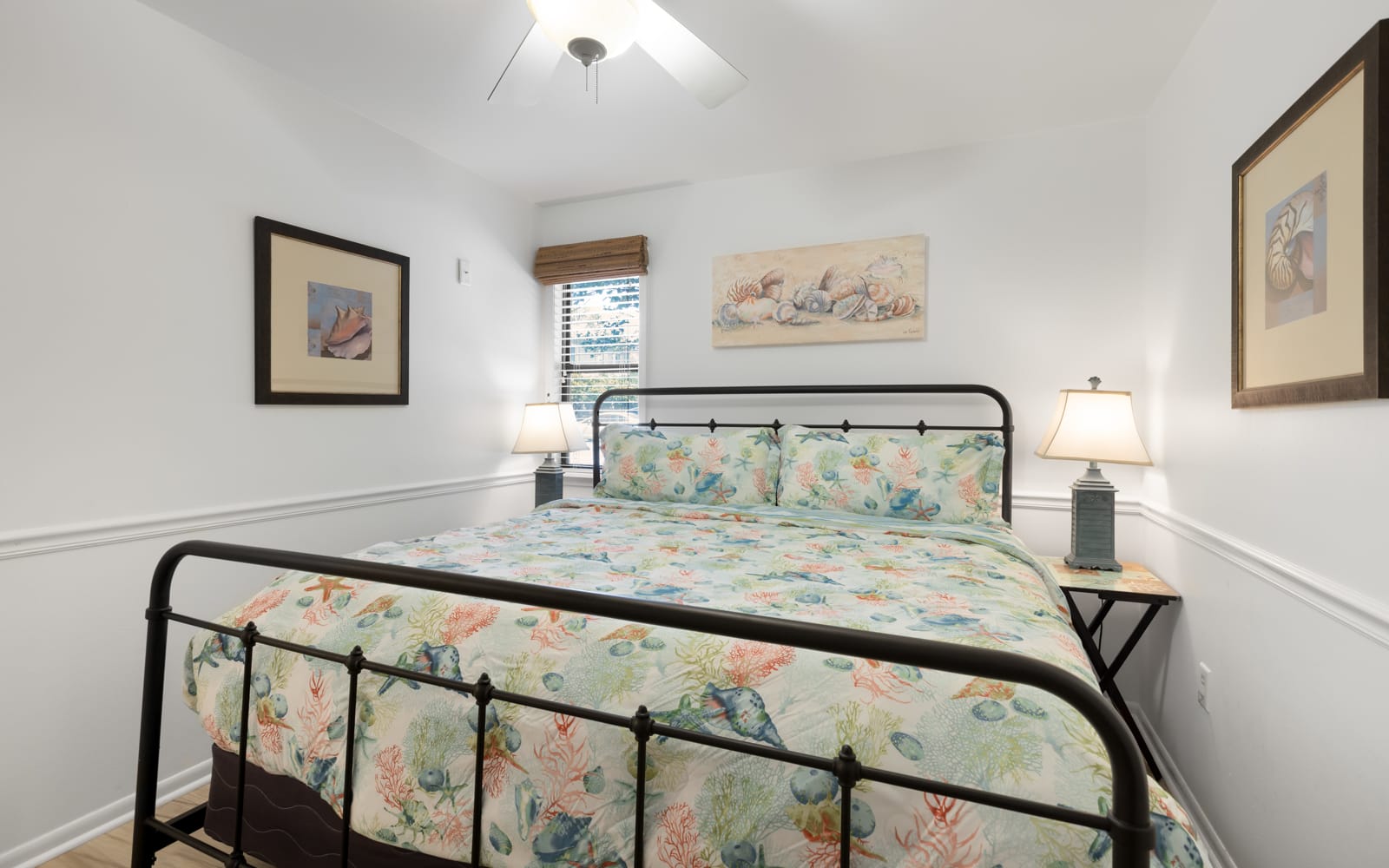 Drift off to sleep on your cozy bed surrounded by beautiful ocean-themed artwork and gentle coastal colors that create a serene retreat.