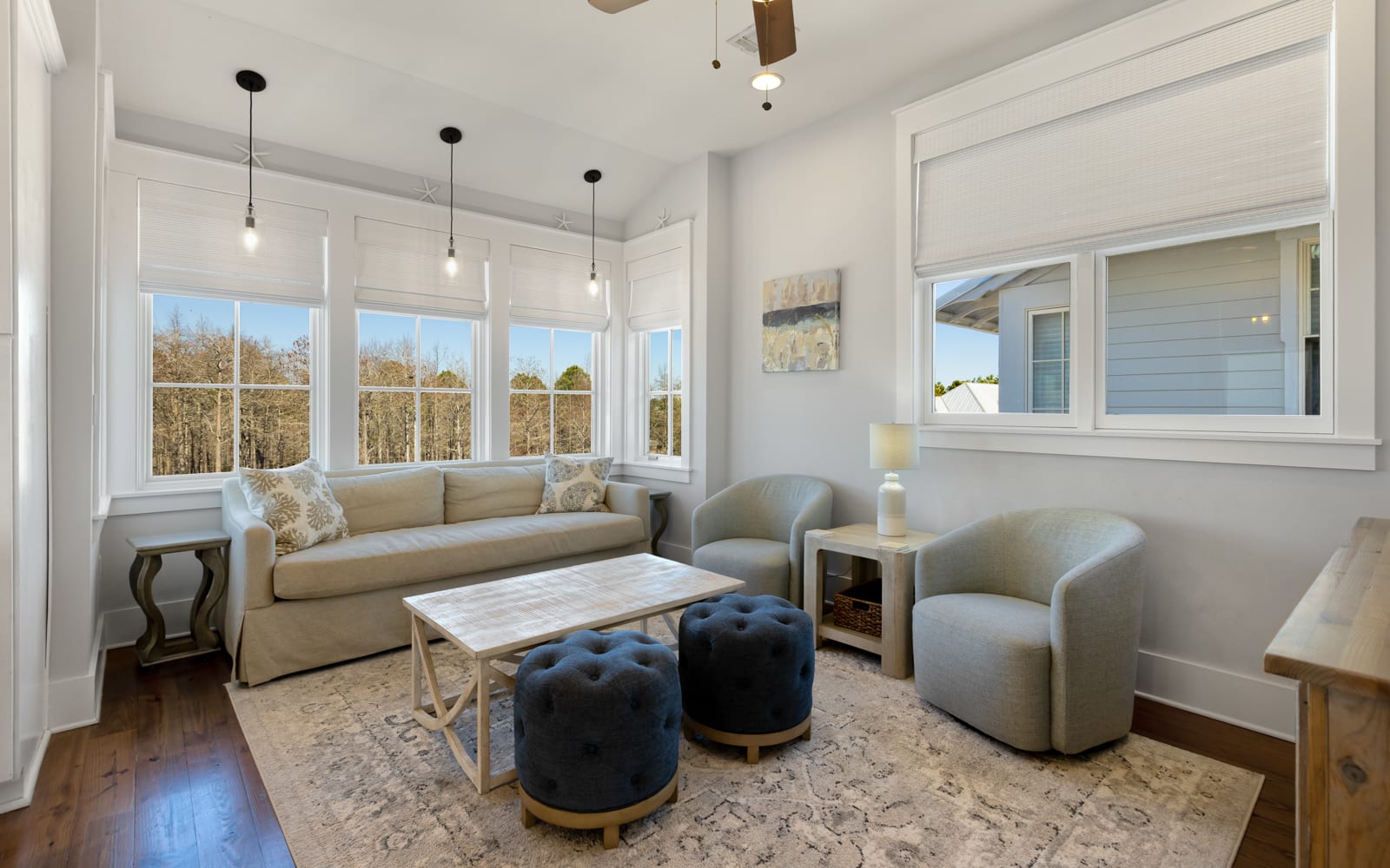 Unwind in your bright living space with plush seating and peaceful treetop views through oversized windows.