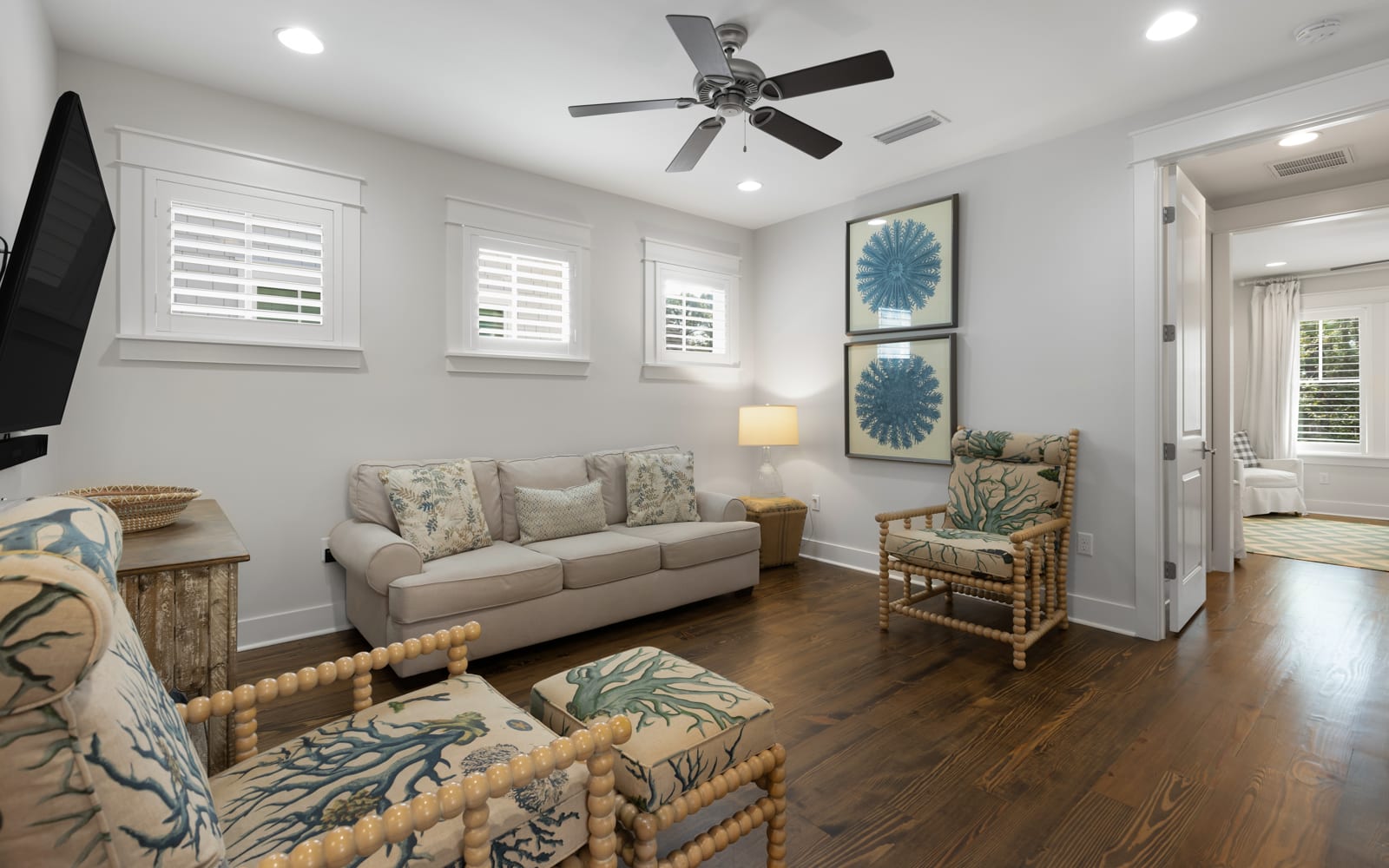 Relax in your bright coastal living room with comfortable seating, ceiling fan, and charming nautical touches throughout.