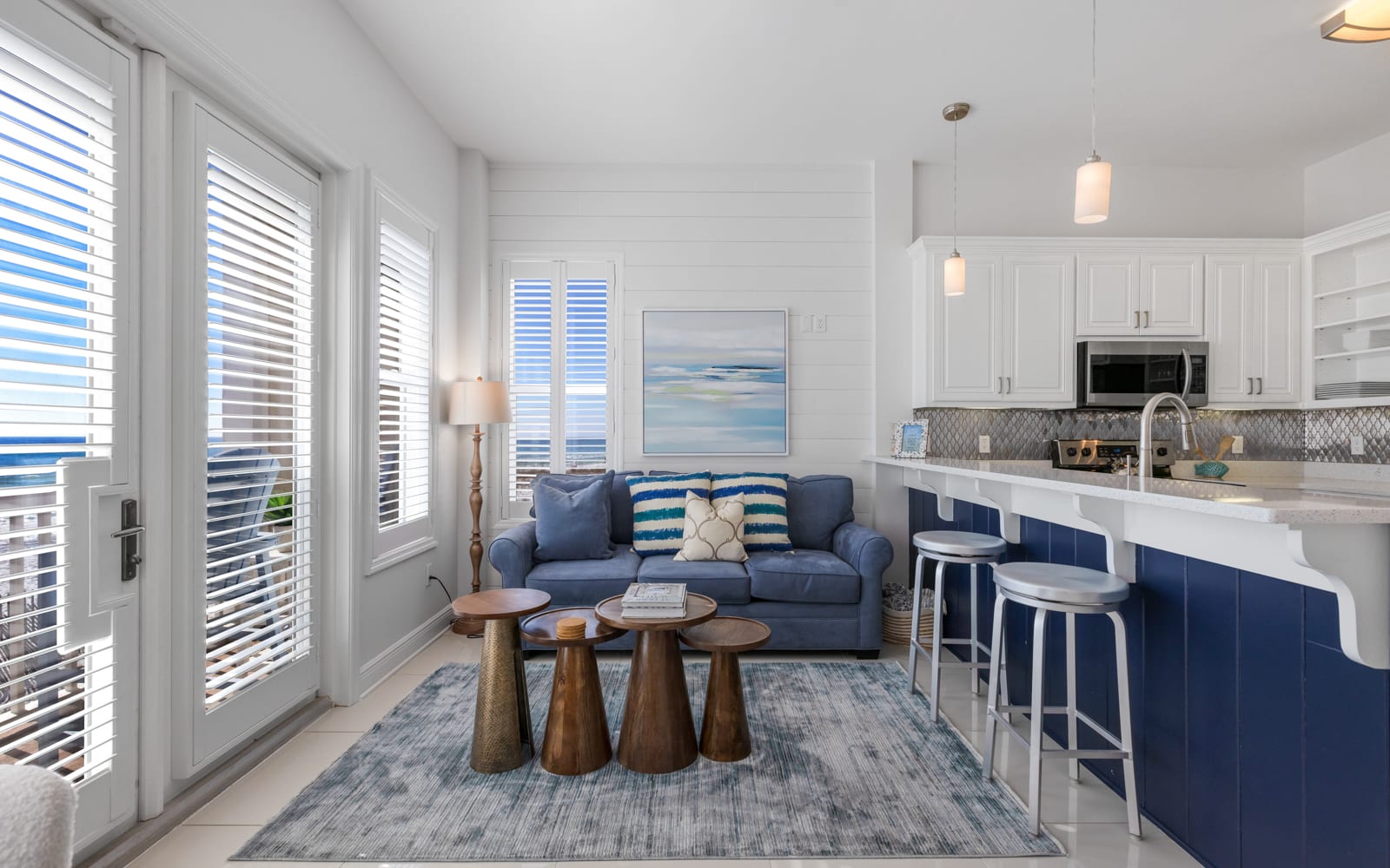 Your bright coastal retreat features an open-concept living space where blue accents meet crisp whites, creating the perfect backdrop for your beach getaway.