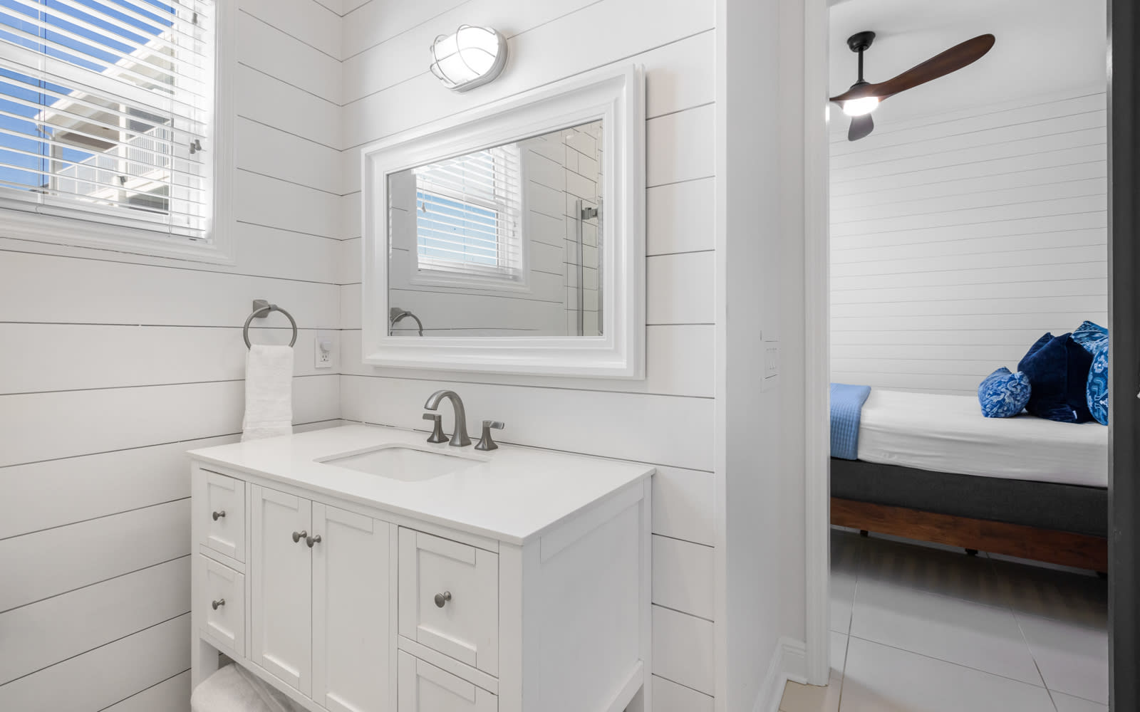 Step into your private retreat with spa-like style—crisp white shiplap walls, elegant vanity, and bright natural light create the perfect morning routine.