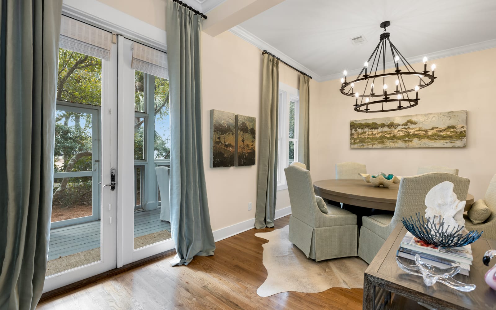 Gather around your elegant dining table where warm light from the wrought-iron chandelier creates the perfect atmosphere for memorable meals together.