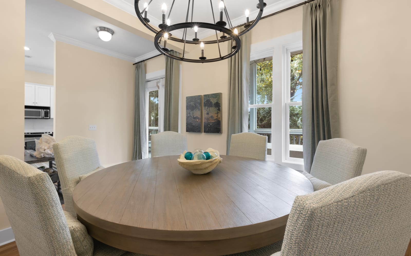 Gather around your elegant dining table for memorable meals, illuminated by stylish chandelier lighting and surrounded by comfortable seating.