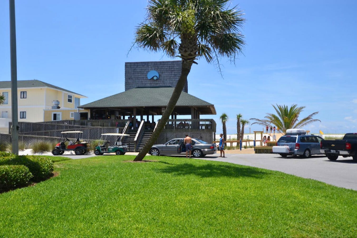 Coastal beachfront area with tropical palms and nearby amenities for a convenient beach vacation experience.