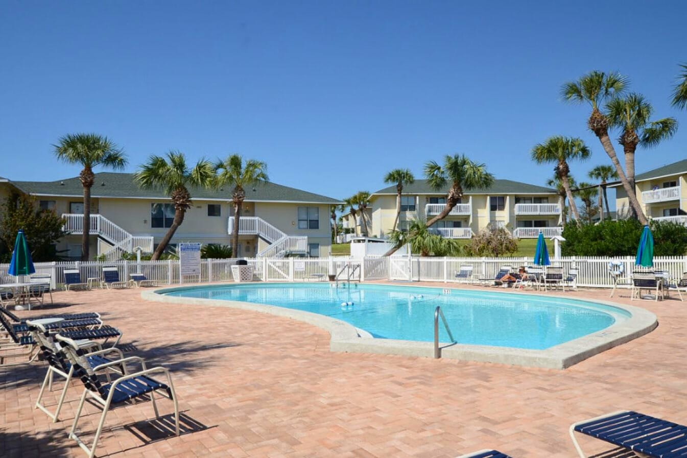 One of Sandpiper Cove Resort’s inviting community pools, surrounded by palm trees and lounge seating—an ideal spot for relaxing, swimming, and enjoying warm coastal sunshine.