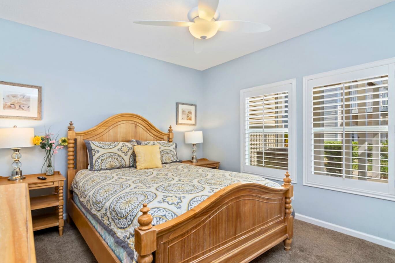 Drift into peaceful dreams in your serene blue sanctuary, where soft morning light filters through plantation shutters and fresh flowers welcome you home.