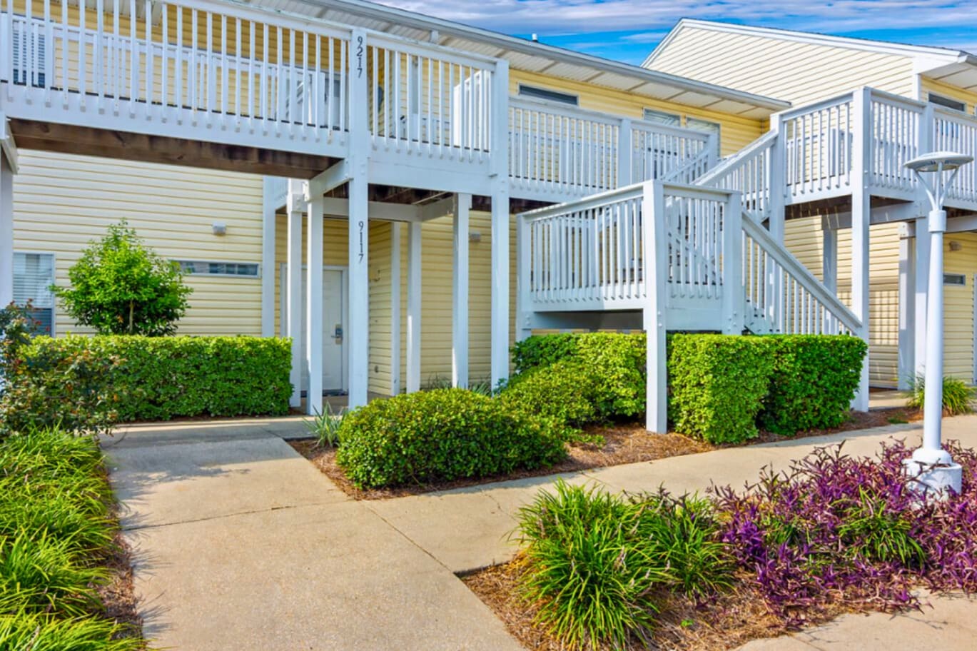 Multi-level vacation rentals with private balconies and lush landscaped grounds create a welcoming coastal retreat atmosphere.