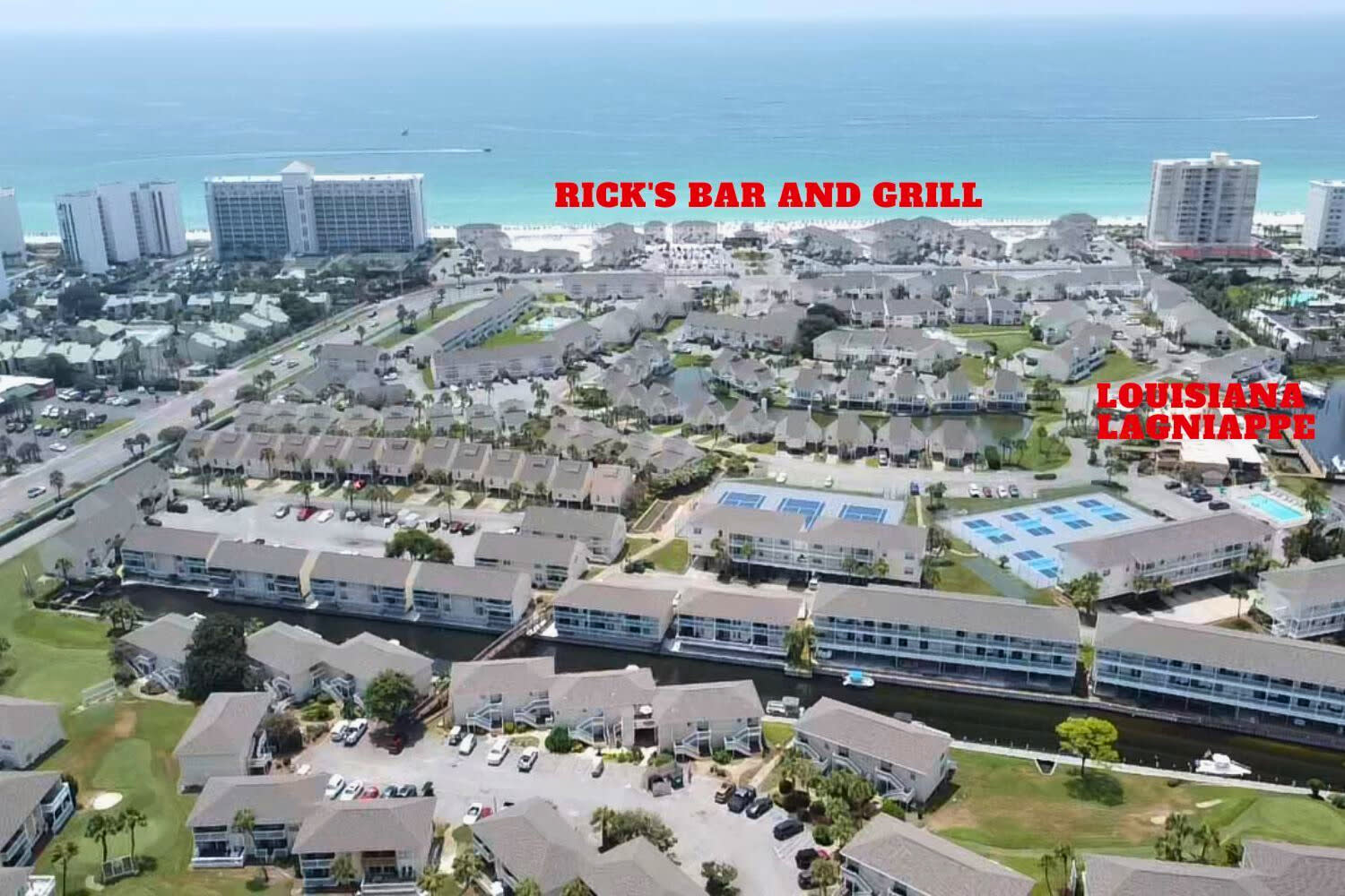 Aerial view showcasing the property's location near pristine beaches and local dining, with Rick's Bar and Grill nearby.