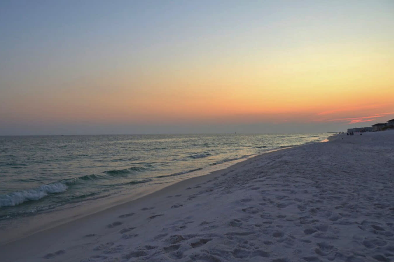 Peaceful Gulf shoreline at sunset, where soft waves meet sugar-white sand and vibrant coastal colors create the perfect backdrop for evening walks and unforgettable beach moments.