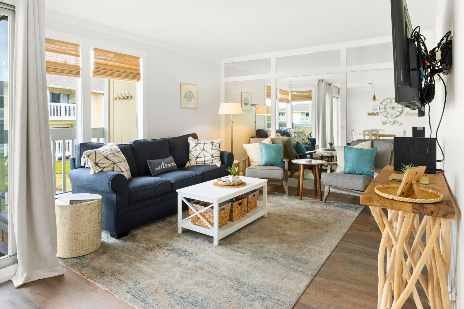 Sink into your spacious living room where coastal charm meets comfort—plush seating, warm wood accents, and abundant natural light create your perfect retreat.