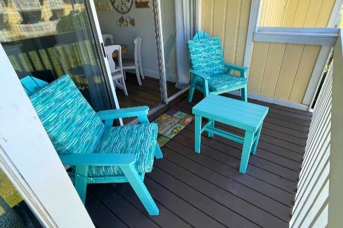 Unwind on your private deck with cheerful turquoise seating, where morning coffee and evening sunsets become your daily ritual.