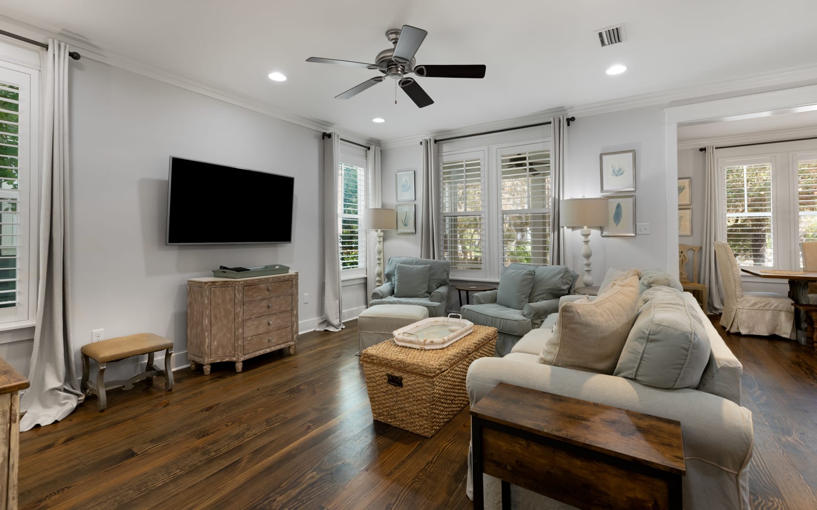 Sink into plush seating in your bright living room, where natural light floods through plantation shutters and a ceiling fan keeps you comfortable.