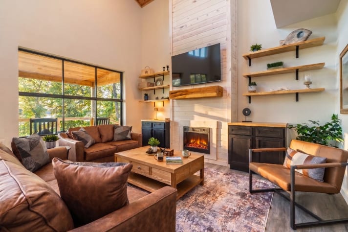Great room with leather seating, electric fireplace, and smart TV — the after-dinner… Douglas Lake, Tennessee Cabin Rental - Gallery Image #18