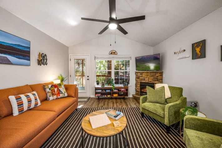 This inviting living room features cozy seating, a stone fireplace, and a smart… Pigeon Forge, Tennessee Cabin Rental - Gallery Image #3