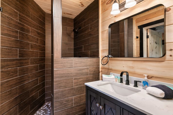The second-floor king suite includes a private ensuite bath with a walk-in shower… Sevierville, Tennessee Cabin Rental - Gallery Image #26